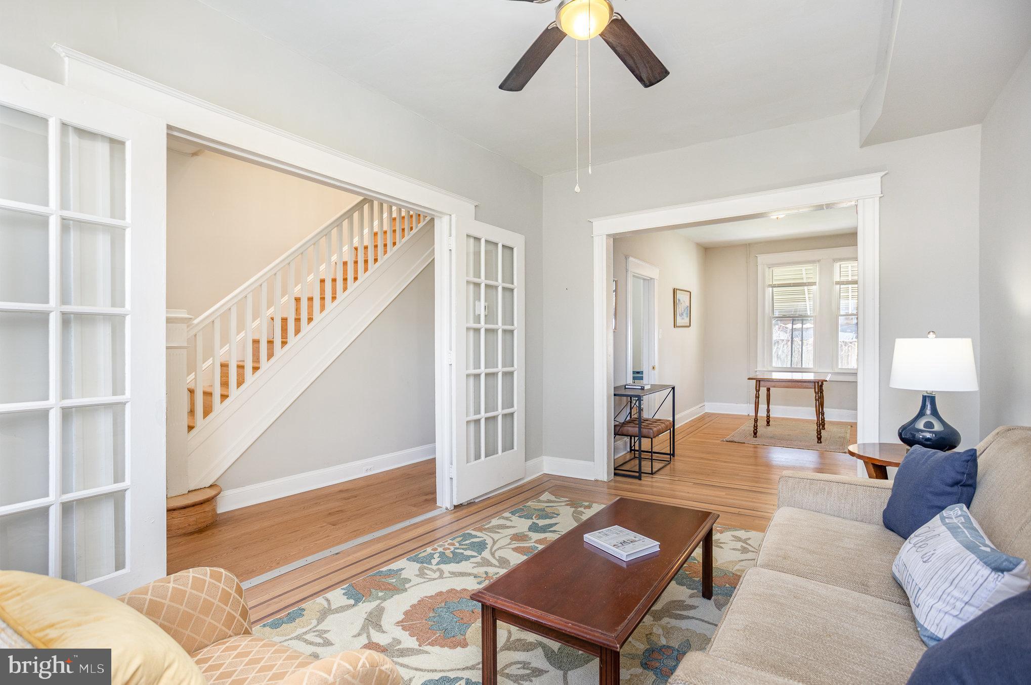 This beautiful freshly painted, porch-front rowhouse, offers the perfect blend of character & contemporary updates. Step through the foyer, and into the elegant French doors lead into a cozy living room with mahogany inlaid hardwood floors, then flow into a separate dining area—ideal for hosting formal dinners. The stylish, modern kitchen is built to impress with Quartz countertops and stainless steel appliances, including a refrigerator, range, dishwasher, and pot racks—perfect for cooking and entertaining. You can circle back to the foyer from the kitchen.

Upstairs, you’ll find 3 generously sized bedrooms with newly refinished hardwood floors and a full bath. The partially finished lower level offers flexible space for a family room, office, 4th bedroom or workout area, along with a half bath, laundry, and additional storage. Out back, enjoy a private fenced yard and covered rear porch—a great setup for BBQs, outdoor dining, and letting pets play. Stay comfortable year-round with central air (2026) and efficient, recent radiator heat.

With central AC installed in 2026, gleaming hardwood floors (refinished 2025), and abundant natural light streaming through modern windows (2023), this home is move-in ready and awaits its new owner.

Ask us about down payment and closing cost grants—you might be able to own this home for less than you pay in rent! Schedule your showing today!