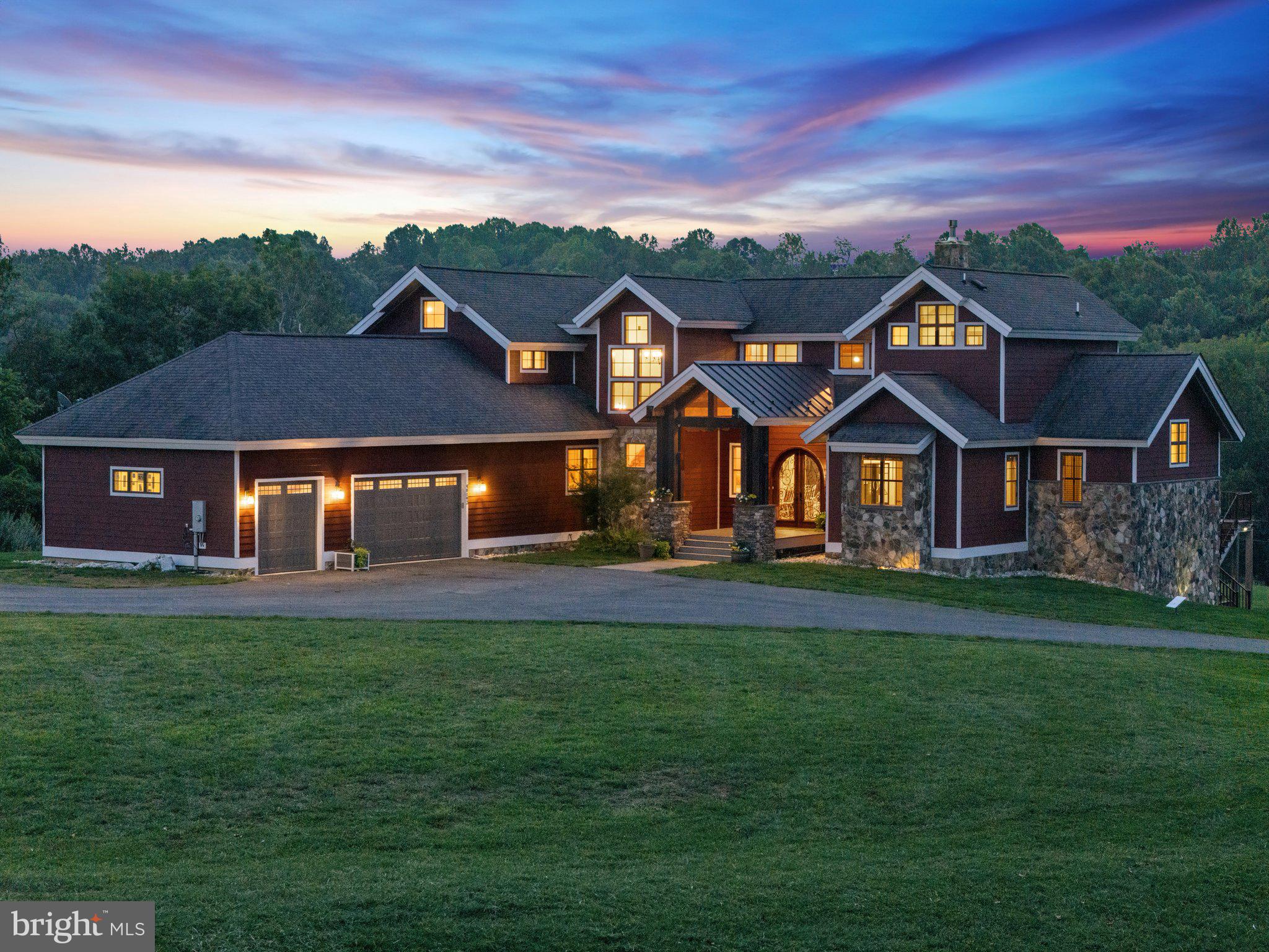 Welcome to Millcreek Meadows, a custom craftsman-style estate nestled on 20 bucolic acres in the heart of Lovettsville, Virginia. This exceptional property was meticulously designed by its owners, offering unique touches and quality craftsmanship throughout.

The home features a stunning arched front door that opens into an inviting open floor plan, where vaulted ceilings and exposed timber beams accentuate the spacious family room. Here, a floor-to-ceiling stone fireplace with a gas insert serves as the room's focal point. The adjacent dining area comfortably seats twelve, perfect for gatherings large or small.

The gourmet kitchen is a chef's delight, boasting a large island, custom quality cabinets, and top-of-the-line appliances, including a six-burner cooktop with griddle and a commercial vent hood. A pass-through window to the screened deck makes entertaining effortless.

The main-level primary suite is a serene retreat with high ceilings, rich wood floors, and access to the rear deck. The luxurious en suite bathroom features custom double vanities and thoughtful design details. An additional main-level guest suite offers comfort and privacy, while the office and a well-appointed mudroom—complete with a dog shower—add convenience.

Upstairs, you’ll find two additional bedrooms, each with en-suite bathrooms, and a large multi-purpose room that can adapt to your needs. The finished basement continues the theme of versatile living spaces, featuring an industrial vibe with concrete floors, a large bar and rec room, gym space, and a media room.

Millcreek Meadows also includes a charming 2-bedroom guest cottage, perfect for in-laws, guests, or short-term rental opportunities. The guest cottage features a cozy living room with a gas fireplace, a kitchen with island seating, a primary bedroom suite, and a second bedroom with a hall bath.

This property’s 20 acres provide ample space for gardens, livestock, or even a family compound, with approved subdivision for a 5-acre lot. The picturesque setting includes a pond with a duck house, adding to the charm of this rural retreat. Despite its peaceful location, Millcreek Meadows is just 15 minutes from shopping and major commuting routes, offering the perfect blend of serenity and convenience.

Don't miss the opportunity to make Millcreek Meadows your dream home!
