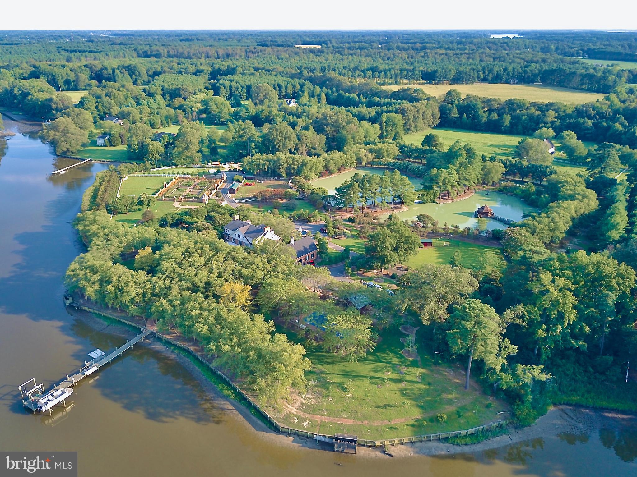 The perfect Eastern Shore escape from the rest of the world.  Situated on Glebe Creek with 12.7 acres of well-planned outdoor amenities including approximately 1,300' bulk-headed shoreline, private pier with electricity, hot & cold water, two 10,000 lb boat lifts, 2 jet ski lifts, and floating docks.    Upon arrival to the gated entry, your stresses of the day melt away as you drive across the wisteria bridge over the 2 acre pond to this stately brick home. Entering the home you will notice the extensive heart pine wood floors and custom millwork.  Expansive kitchen with wide water view perfect for large scale entertaining, a massive island, 2 G.E. Monogram refrigerators, 2 Wolf microwaves, 2 Wolf ovens, 2 Wolf warming drawers, a Wolf six-burner range/oven with French cooktop, 2 cooper farmhouse sinks and Brazilian Quartzite countertops. Five gas-controlled fireplaces can be found throughout the home. The elevator gets you from the first to the third floor with ease and is custom painted by renowned Smithsonian artist. The property boasts many places to relax including brick patios and paths, 2 Vicenza stone gazebos and 3 cast iron gazebos throughout property.  Family and friends will enjoy the many places to play including the sports court, and the 75 yard, par 3 artificial green with sand trap, the football/lacrosse field, 50'x20' heated in-ground pool with diving board, 40' x 60' playground with playhouse, Large raised-bed colonial vegetable garden with irrigation, numerous outbuildings and 3-car garage leading to a conditioned wine room.