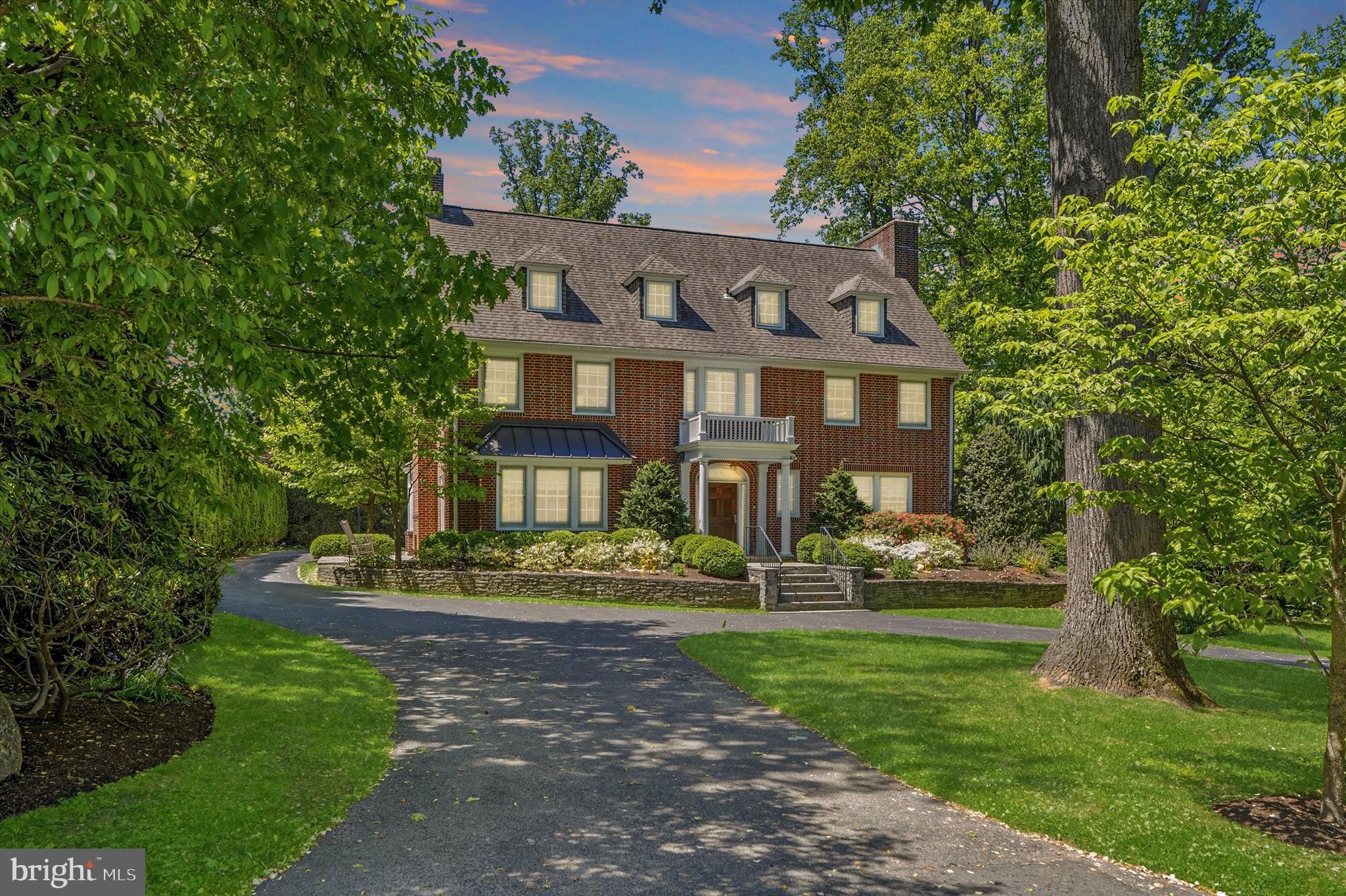 Set on a beautiful tree-lined Main Line street, this stately three-story brick residence, built in 1925, blends timeless architecture, historic character, and thoughtful modern updates with a sense of elegance that feels both refined and welcoming. A circular driveway, mature landscaping, and classic brick exterior create a distinguished first impression, while the location offers exceptional access to Villanova University, Rosemont College, nearby train stations, shopping, dining, and the conveniences of the Main Line.

Inside, a gracious center hall entry introduces the home’s warmth and craftsmanship, with original hardwood floors, high ceilings, abundant natural light, and rich architectural details throughout. To the left, a handsome study features built-in bookshelves, pocket doors, a fireplace, and French doors that open to a side patio with an outdoor fireplace—an inviting setting for quiet mornings, work-from-home privacy, or intimate outdoor gatherings. To the right, the entry leads past two coat closets into a spacious living room with its own fireplace, recessed lighting, and French doors opening to the rear patio. Just beyond, the outdoor living space begins beneath the covered balcony of the owner’s suite and continues to a generous flagstone patio overlooking the rear grounds.

The dining room, located just beyond the study, offers another beautifully scaled gathering space and includes its own fireplace, creating an elegant and memorable setting for entertaining. The dining area opens to the updated kitchen, where classic style meets modern function with a Wolf stainless steel range, stainless steel hood, Sub-Zero refrigerator, tall cabinetry, subway tile wall detail, center island, and excellent flow into the pantry and laundry room. A powder room completes the main level.

The second and third floors offer five bedrooms, three full baths, and two additional flexible rooms that provide wonderful options for a fitness space, studio, office, guest overflow, or creative retreat. 

The owner’s suite is bright and inviting, with large windows, a walk-in closet, a spacious walk-in shower, and its own covered deck/balcony overlooking the rear property. The additional bedrooms and flex spaces create a versatile layout well-suited for modern living, while the updated baths bring a fresh, polished feel to the home’s classic design.

The finished basement adds even more usable living space, along with an additional full bathroom, making it ideal for recreation, media, fitness, play, or guests. Thoughtful improvements include a whole-house generator and whole-house water filtration system, adding comfort and peace of mind.

Outside, the property continues to impress with a heated, fenced pool surrounded by pavers, multiple patio areas, mature landscaping, and a detached rear garage that offers flexible parking and storage options.

With five bedrooms, two additional flex rooms, four and a half baths, classic Main Line presence, updated finishes, and a rare combination of walkability, privacy, and historic charm, this home offers a truly special opportunity in one of the area’s most cherished locations. 

Proximity to Villanova also provides access to the Friends of Villanova program, an added local benefit for those who wish to explore university fitness and community amenities.