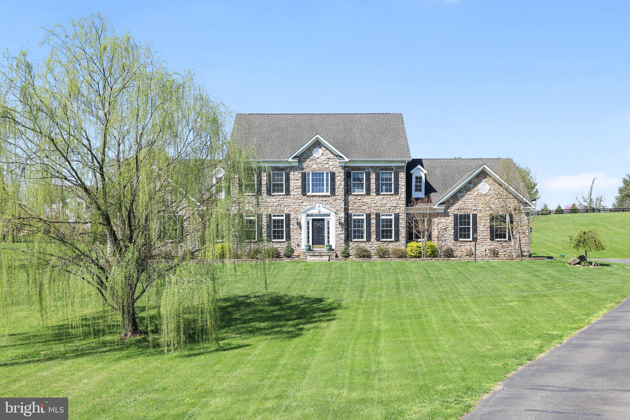**Elegant Stone-Front Colonial with Main Level Primary Suite** Set on 3.3 beautifully landscaped acres in a highly desirable location, this 4,000+ square foot, 5-bedroom, 3.5-bath stone-front colonial offers a rare blend of timeless elegance, modern comfort, and small-town charm. With a stately exterior and spacious interior, this home is perfect for those who want room to breathe — both inside and out. Step inside to find a grand two-story family room with dramatic arched windows, a cozy gas fireplace, and an open-concept layout ideal for everyday living and entertaining. Hardwood floors, classic columns, and designer touches create a warm yet sophisticated atmosphere. The gourmet kitchen opens to the living and dining areas, keeping everyone connected. The main-level primary suite provides the ease of one-floor living with a spa-inspired jetted tub, dual sink vanity, and a large walk-in closet. The primary suite also encompasses a sitting room, currently used an office. Upstairs, you’ll find two linen closets and four additional spacious bedrooms and two full bathrooms, each with double sinks. A full walk-up basement offers endless possibilities for customization, from a home gym to a media room. Plumbing is already in place to add a full bathroom.

Outside, enjoy your own private oasis — an expansive stamped concrete patio with multiple seating areas, a built-in fire pit, and serene views of rolling lawn and mature trees. With fiberoptic internet, this home easily supports remote work and streaming.  And when it’s time to explore, you’re just minutes from Routes 7, 9 and 287, downtown Purcellville, only 15 minutes to Leesburg or Middleburg, 25 minutes to Dulles International Airport and 45 minutes to Washington, D.C.

Live the Western Loudoun lifestyle and spend time off hiking the Appalachian Trail, tubing down the Shenandoah River or exploring historic Harpers Ferry. Discover award-winning restaurants, wineries and breweries, shop local at organic farmers markets and boutique stores. Experience small-town charm with holiday parades, outdoor music festivals or take in a baseball game at iconic Firemans Field. Biking, walking and running are close by on the scenic W&OD Trail.

This is more than just a home — it’s a lifestyle of peace, beauty, and connection. Don’t miss your chance to make it yours.