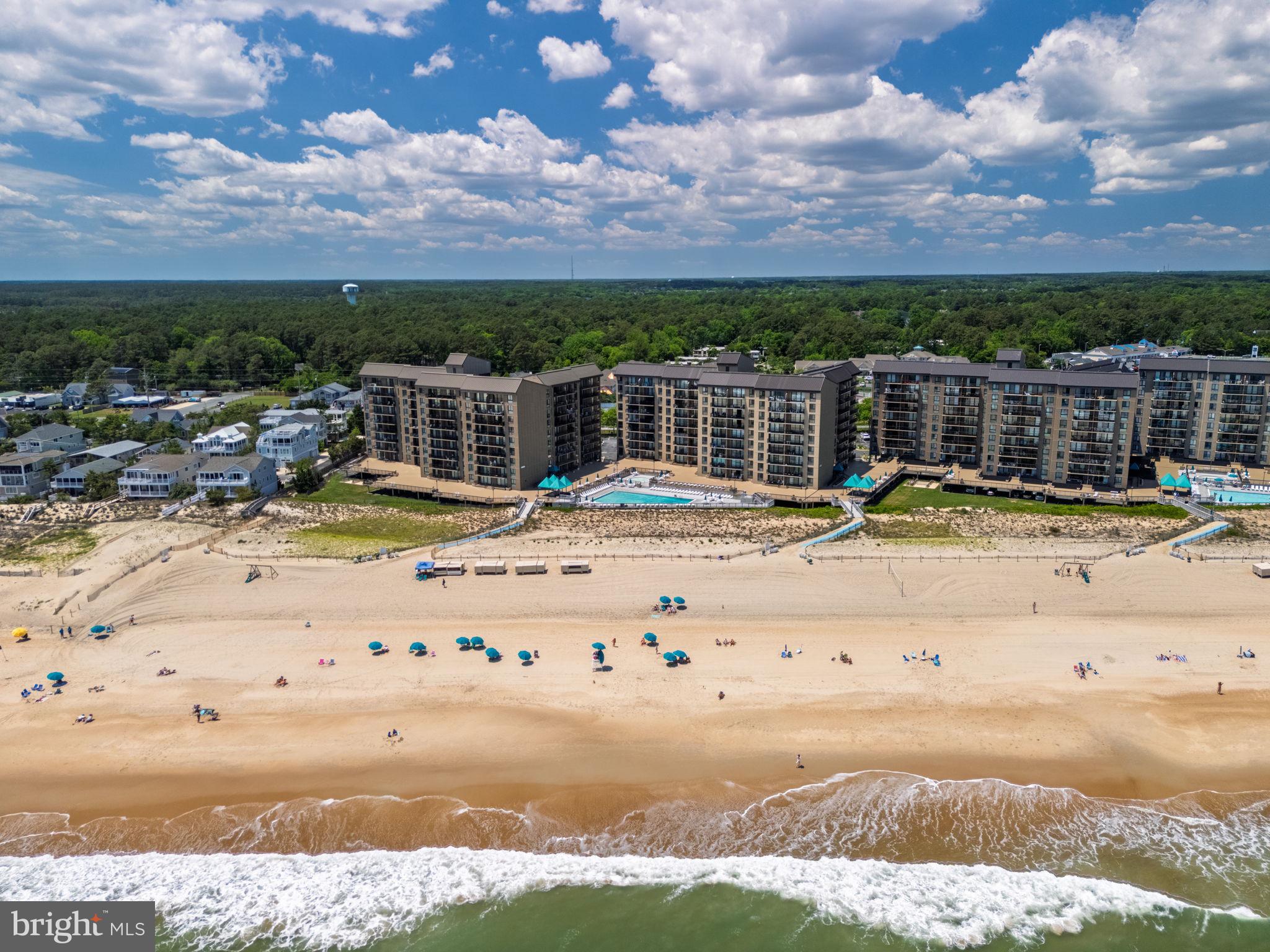 Welcome to coastal living at its finest in the Georgetowne House at Sea Colony in Bethany Beach. This beautifully updated 3-bedroom, 2-bath oceanfront condo offers breathtaking views of the Atlantic and the ultimate beach lifestyle. Freshly painted and featuring new luxury vinyl plank flooring throughout, this bright and spacious condo that has only ever had one owner is designed for both comfort and relaxation. Enjoy stunning ocean views from the private balcony, creating the perfect setting for morning coffee or evening sunsets. Stretch out in two bedrooms, living room, and the a den that is convertible to a third bedroom, creating the perfect setting for morning coffee or evening sunsets. Conveniently located near two elevators, with a designated parking space under cover, you’ll enjoy easy access from parking directly to the condo or down to the sandy beach and indoor and outdoor pools. Sea Colony is known for its award-winning amenities, including: private beach access, 12 swimming pools (including two indoor), world-class tennis and pickleball facilities with indoor and outdoor courts, state-of-the-art fitness center with classes, trainers, and weight rooms, all located just a short walk or bike ride to downtown Bethany Beach., you’ll love being close to the charming boardwalk, boutique shops, and fabulous restaurants. Whether you’re looking for a beach getaway, investment property, or year-round coastal retreat, this exceptional oceanfront condo offers the very best of the Sea Colony lifestyle.