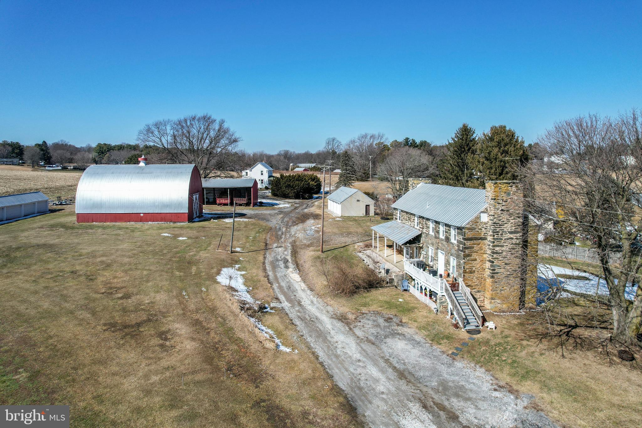 Rare opportunity to own a 130-acre farm in Ag Preservation featuring approximately 112 acres of rich cropland and 12.9 acres of scenic woodland with a stream. The property includes two homes and multiple outbuildings, ideal for farming, investment, or peaceful country living. The single-family home offers an open kitchen and dining area, living room with exposed ceiling beams, laundry room and mud room on the main level, and three bedrooms with one full bath upstairs. Additional features include replacement siding and windows, covered front porch, rear concrete patio, and a new hot water heater (2023). The stone duplex at 3070 Marston Rd provides additional living space or income potential. Unit B includes a living/dining room combo, kitchen, and full bath on the main level, with two bedrooms upstairs plus a third room currently used as a walk-in closet. Updates include plumbing, electric, windows, indoor stairway and risers (2019), LVP and tile flooring, hot water heater (2020), and chlorine water treatment system (2024). Outbuildings include a 36x56 barn, 24x64 machine shed, 6-bay equipment building, and 4-car detached garage with electric. Metal roofing on the homes and outbuildings has been recoated, the barn has been painted, and all 10 garage doors have been replaced. Property is served by two septic systems and one well. A solid agricultural property with established infrastructure and multiple possibilities. Drone footage: https://youtu.be/9RDzccchIyE?si=blPo0hMgcWWKcKFp