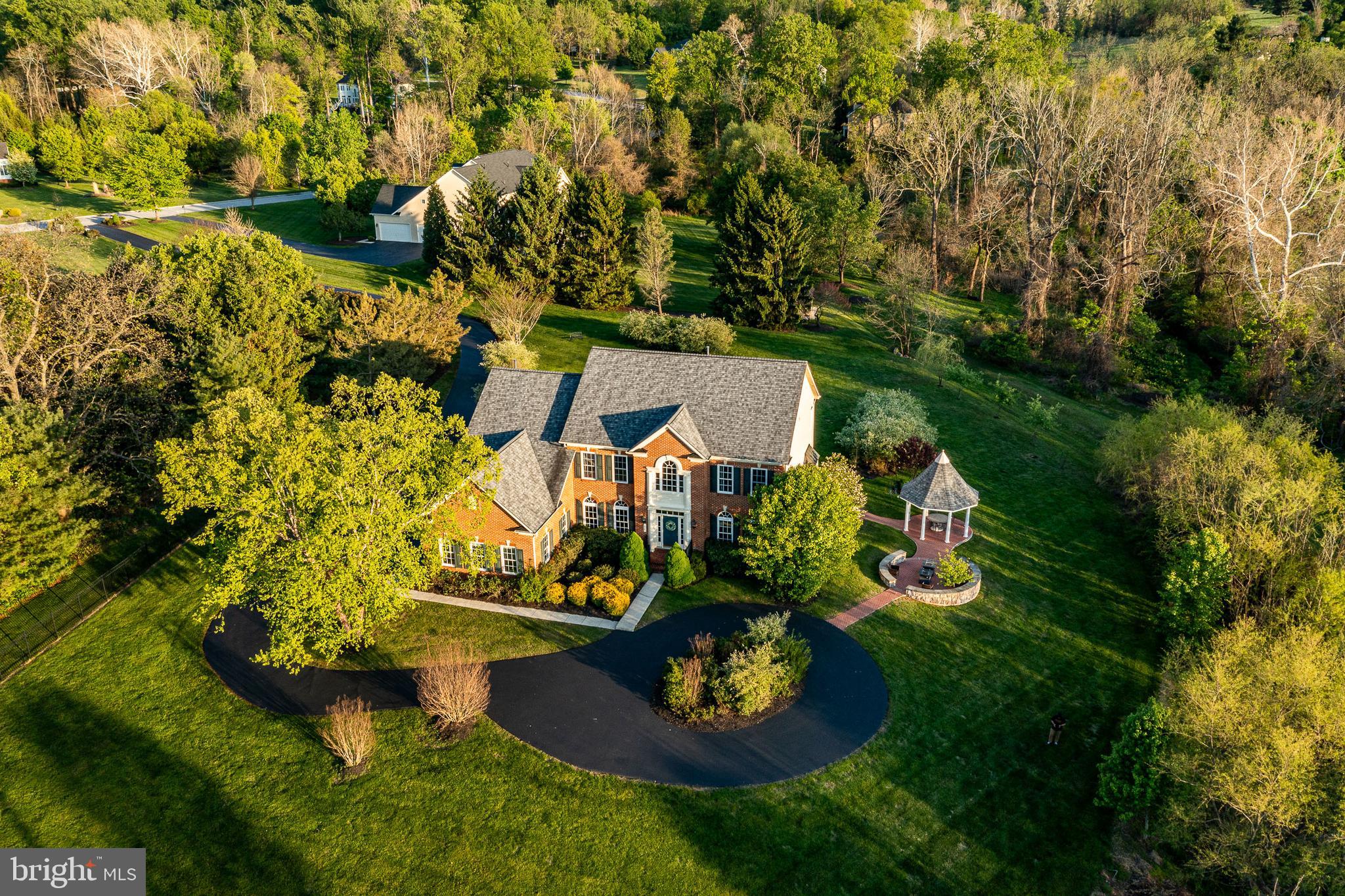 Set on a picturesque 3 acres in sought after Anderson Farm, 12 Schofield Drive makes a striking first impression with its stunning brick façade and elegant circular driveway, centered around a beautiful fountain that creates a grand and welcoming approach. This impressive 6200 sqft 5 bedroom, 4.5-bath home is thoughtfully designed for both everyday comfort and elevated entertaining offering the perfect blend of luxury, space, and resort-style outdoor living.
Step inside to a dramatic front hall featuring a sweeping staircase, setting the tone for the home’s elegant yet inviting interior. A newly renovated gourmet kitchen (2022) anchors the home with high-end appliances, granite countertops, and a spacious walk-in pantry, perfect for both daily living and hosting. A sunlit breakfast room is open to the kitchen, ideal for casual dining, with a coffee bar and access to the back patio, perfect for sipping coffee in the morning. The kitchen flows seamlessly into a large family room featuring a dramatic cathedral ceiling and a gas fireplace with two story stone surround. Formal living and dining rooms provide classic entertaining spaces, with the dining room currently styled as a pool room for added versatility. A private main-floor home office with glass French doors offers the perfect work-from-home setup overlooking the manicured grounds. Dual staircases add architectural interest and functionality, while a spacious mudroom and 3-car garage with storage provides everyday convenience.
Upstairs, the primary suite is a true retreat featuring a sitting area and two outfitted walk-in closets; the bathroom includes two vanities,  a private water closet, soaking tub, and a separate walk-in shower, creating a spa-like experience at home. An additional bedroom offers an updated en suite bath and a large walk in closet, while two more spacious bedrooms share a convenient Jack and Jill bathroom with double sink vanities and tub/shower combo.
The 2,000 sqft walk out day-lit lower level expands your living space with an impressive theater/media room with projector, a separate versatile room which could serve as a gym, office or playroom, and a bedroom with updated ensuite full bathroom and walk in shower - ideal for guests, work-from-home setups, or a private nanny suite. There is a new sauna for a spa-like wellness & relaxation experience when used in tandem with the new hot tub and cabana just a few steps outside the walk out, you can enjoy recharging in a quiet nature retreat that is your backyard.
Step outside to one of the multiple outdoor living spaces and the property truly shines. Extensive hardscaping surrounds the home with multiple patios, gazebo, and custom built brick seating area with fire pit - perfect for entertaining. At the rear of the property, a tranquil stream with a charming beach-like setting adds a rare and serene natural element creating an idyllic place to unwind and enjoy the occasional glimpse of a majestic hawk or fox. The large, level yard has enough impervious to add a sizable pool per the township, offering endless potential for more customization. 
Recent improvements (over 300K in upgrades) include a renovated kitchen, extensive landscaping and plantings over 100 added along with thoughtful hardscaping, new circular driveway, new roof (2020), dedicated outlet for a manual generator (2020), 2 new HVAC systems (2022), finished lower level (2021).
A unique opportunity to own a beautifully appointed sunlit home with seamless indoor and outdoor living spaces, create a wellness spa for yourself by indulging in the hot tub, sauna, and unwind listening to nature at the streams edge on a summers eve all set in a sought-after community and convenient location close to all downtown Phoenixville has to offer and minutes to Malvern, Valley Forge National Historical Park, King of Prussia, Route 422, Route 202, I-76, the PA Turnpike, and Greater Main Line destinations.