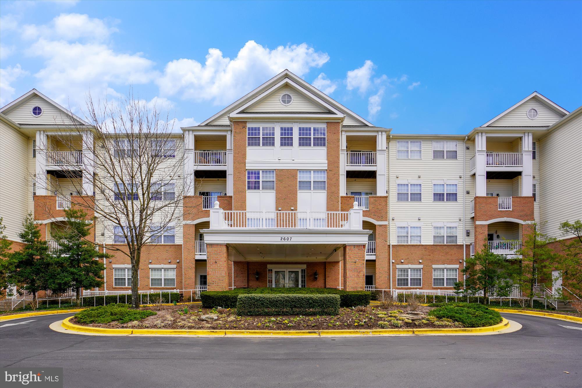 Discover refined, low-maintenance living in this meticulously updated, light-filled residence within The Village at Waugh Chapel, a premier 55+ community. This spacious condominium presents a thoughtfully designed floor plan featuring two bedrooms, two bathrooms, and a versatile den/office, catering to contemporary lifestyles. Interior highlights include an open-concept living area with elegant window treatments, durable engineered wood flooring, and modern white appliances. The primary suite boasts a generous walk-in closet and a luxurious ensuite bathroom. A secondary bedroom provides convenient access to the second full bathroom. Enjoy the convenience of in-unit laundry with ample storage. A private balcony offers serene views of a tranquil pond and walking path. This unit includes secure underground deeded parking (space #12)  and a dedicated storage cage (#42). Residents benefit from a wealth of community amenities, including a social gathering room, elevator access, and convenient refuse rooms on each floor. The property's prime location affords effortless access to the vibrant Waugh Chapel Town Centre, encompassing diverse retail, dining, and grocery options. Commuting is simplified with proximity to Ft. Meade, BWI Airport, rail transport, and major metropolitan areas including Washington D.C., Baltimore, and Annapolis.