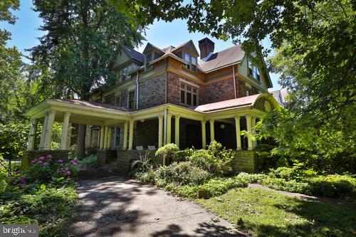 The advent of the commuter rail line to Germantown, brought Philadelphia's own Gilded Age into more bucolic settings. This extraordinary Queen Anne Victorian single, built circa 1887 for Joseph S. Perot; and  home to Governor Martin Brumbaugh from 1912-1924, sits among other significant properties that make up Germantown's Tulpehocken Station Historic District on the National Register of Historic Places.  254  W Walnut Lane is architecturally intact, mechanically updated, and a powerful statement of place.  Approach the "Dutch-style" front door from the wrap around covered porch and enter the spacious entry hall with elegant turned staircase.  Straight back past the back staircase is the  large, eat-in kitchen and rear pantry room.  To the right of the entry is the dining room, living room, and library.  Upstairs is a large sitting room, typical of how Americans lived during Victorian times, and perfect for today's tv  room.  In addition , there are three bedrooms and two full baths.  The third floor has five more bedrooms and two more baths.  The stone construction, half acre of land, beamed ceilings, distinctive wood paneling, carved fireplace mantels, built-in bookcases in several rooms, and tall ceilings- 10 foot on the first floor - all make the house irreplaceable.   House will be ready at the end of June for showings.  Photos to follow . The next owner has a deep respect for history, and is ready to make some history of their own .