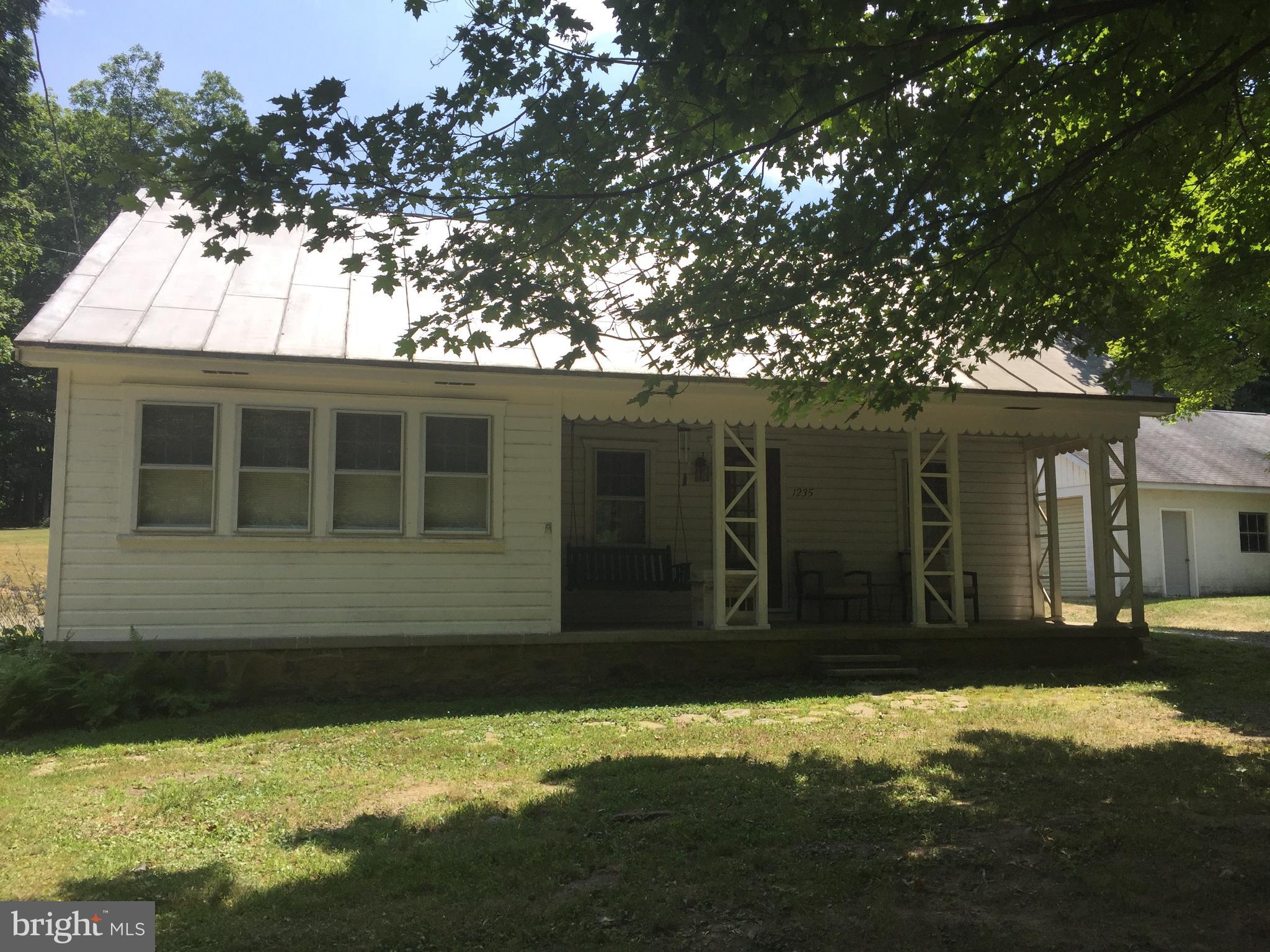 Quaint 2 bedroom home in country setting.  Property offers privacy, wildlife, large 2 car garage with loft for storage, and other outbuildings.  Wood stove in garage is included in sale and can be easily installed by building a chimney.  Wood under pavilion is also included.  Home is wired for a backup generator in case of electric outages. Sellers are motivated to sell, so come check it out and make this home yours.