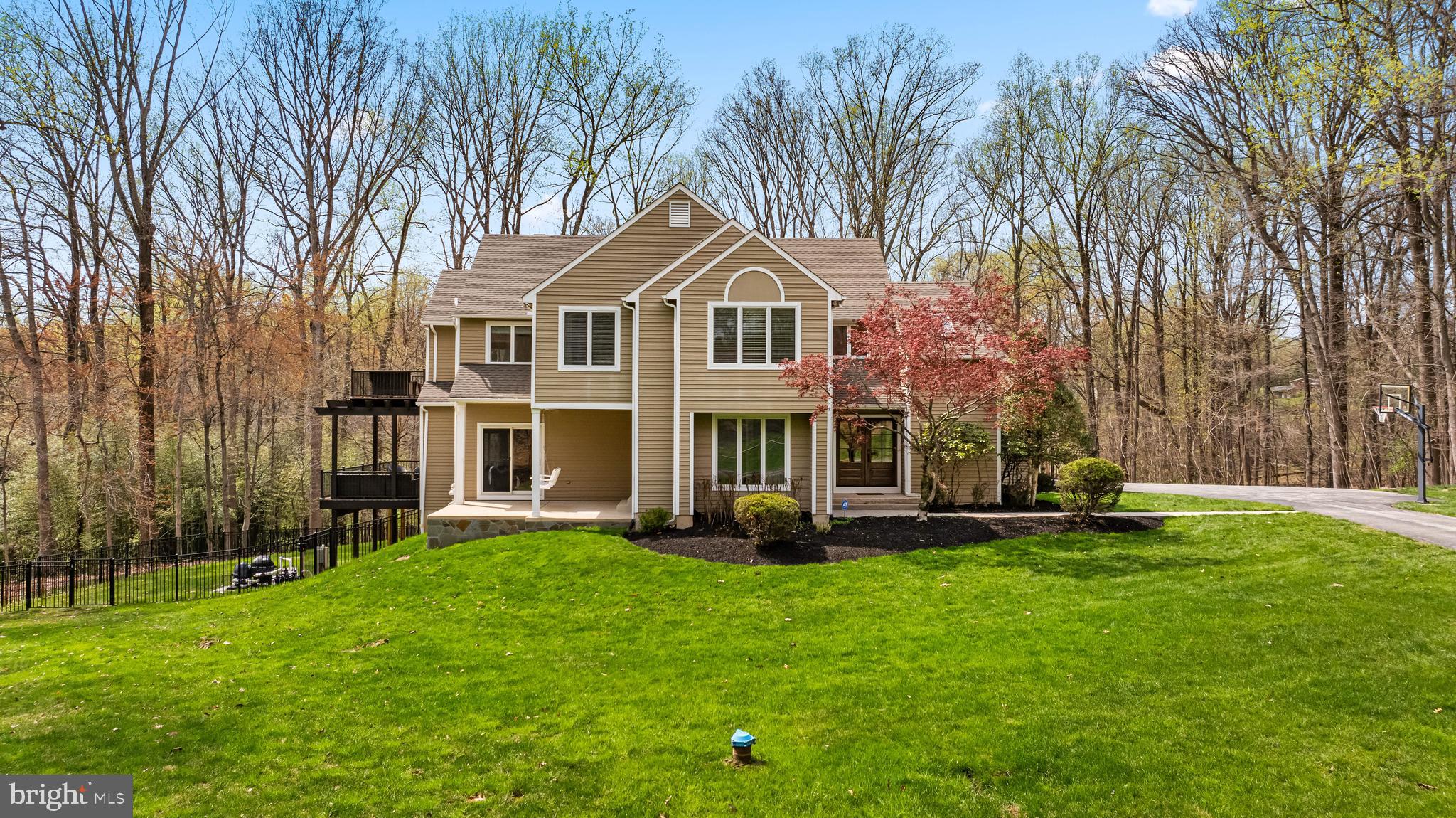 This architecturally impressive contemporary is located on 1.8 serene acres at the end of a cul-de-sac and boasts a stunning tiered deck that overlooks the magnificent inground pool with a waterslide and the expansive patio with fireplace and multiple seating areas - all encircled by stunning views of the woods. The interior features soaring ceilings, tons of windows, family room with a stately stone fireplace off the eat-in kitchen and a sprawling primary suite that includes a custom dressing room, laundry and luxury bath with soaking tub, oversized shower and gorgeous custom cabinetry.  The spacious lower level offers a large rec room area, 5th bedroom & full bath, exercise room and plenty of storage space! For every night of the week and special entertaining events, this unique contemporary supports spaces for everyone both inside and out!