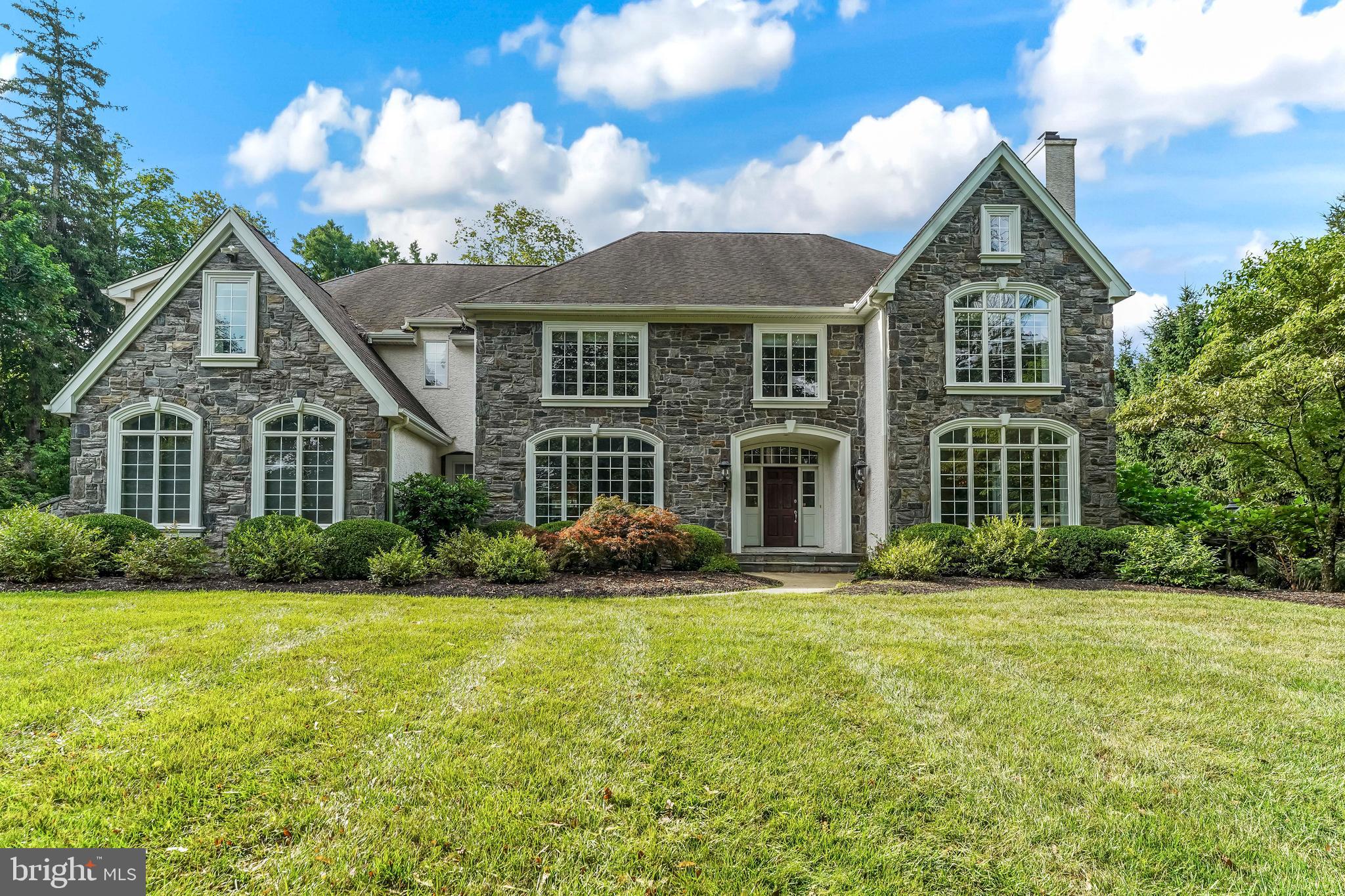 One of the area’s most extraordinary homes in one of the most desirable locations is now available. Quarried gray fieldstone and spectacular arched casement windows create a majestic presence on approach. You want for nothing in this magnificent property, buffered by woods adjacent to the conserved Brandywine Battlefield.  This home is sited on 2+ secluded acres, yet close to everything. You will appreciate the high quality construction from Megill Homes, the Brandywine Valley’s premier custom home builder.  Inside, a gracious flagstone front porch opens to a front to back foyer, and generous room sizes throughout the home. The brilliant floor plan provides for a “living wing” of the home that includes the kitchen with Viking appliances and Subzero fridge, informal dining area, a family room with stone fireplace and vaulted ceilings and a wall of windows to the fenced back yard and woods. Access to the low maintenance composite deck is from both the informal dining area and the main foyer, and the sun room. 
The “west wing” of the home includes the formal living room with fireplace, office and sunroom. The formal dining room and butler’s pantry will comfortably host your events.  Use the main or back staircase to go up to the bedroom level.  The primary bedroom suite is over the west wing, creating an oasis with walk-in closets and bathroom backing to the woods.  On the east wing, four additional guest bedrooms all with en suite bathrooms, and abundant closets. To the walkout lower level, an additional guest bedroom, full bathroom, recreation room, theater room, and additional open area for entertaining and gathering.  All of your power needs are secure with 3x 200 amp panels, a backup generator, and a 50 amp EV outlet in the garage.  Outside, the property includes a fenced vegetable garden that currently produces eggplant, shishito, bell, and hot peppers, cantaloupe, blackberries, several tomato varieties, and an herb garden with sage, mint, basil and thyme. Serviced by the highly rated Unionville-Chadds Ford School District, and close to numerous private schools in both Pennsylvania and Delaware.  Nearby amenities include both upscale and everyday shopping and dining. Within 10 minutes is Whole Foods, Wegmans, Giant, Target, Pottery Barn, Anthropologie. Minutes to access to US-1, Philadelphia airport (22 miles/35 minutes), Wilmington Amtrak (14 miles/30 minutes).