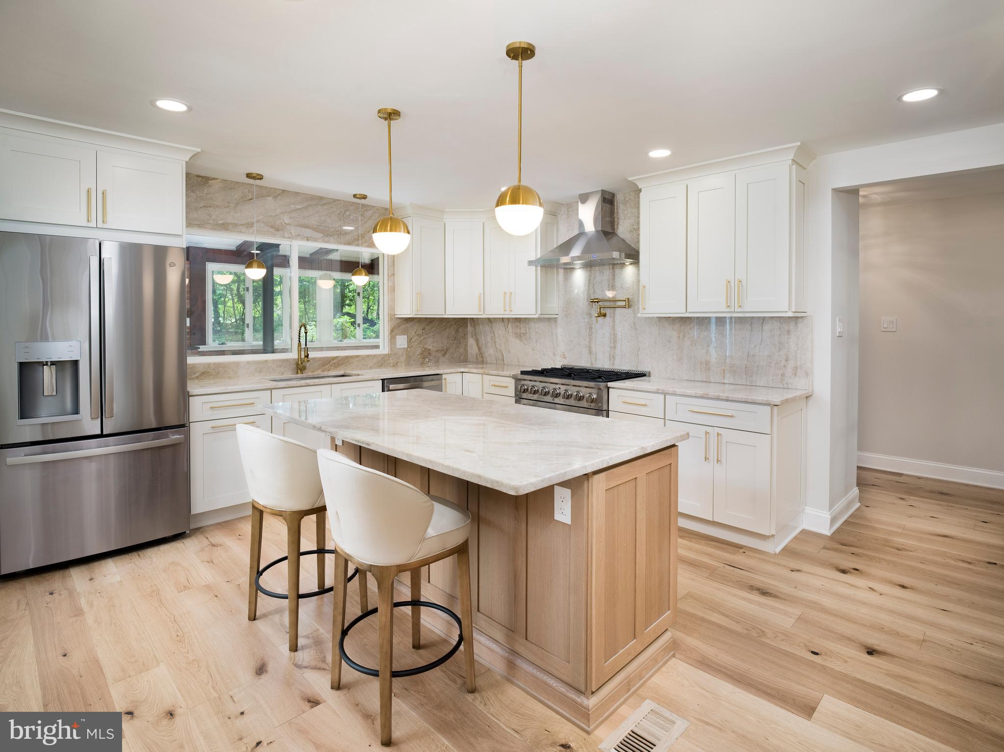Welcome to 581 Woodland Drive, a beautifully renovated 4-bedroom, 2.5-bath colonial nestled on a full acre in the sought-after Upper Merion Area School District. This forever home seamlessly blends timeless architecture with contemporary finishes, offering over 2,675 square feet of refined living space—plus an additional 750 square feet in the fully finished basement. Set on a quiet cul-de-sac, the property is surrounded by tall, mature trees, with a private drive leading to a side-entry 2-car garage. The home's layout supports today’s lifestyle, with flexible spaces and upscale details throughout. Inside, the bright and spacious living room welcomes you with custom built-in shelving and a gas fireplace. Across the entryway, the elegant formal dining room offers an ideal setting for hosting family and friends. At the heart of the home, a chef’s dream kitchen features custom antique white shaker and white oak cabinetry, luxurious Taj Mahal Quartzite countertops with backsplash, and a central island perfect for gathering. Just beyond the kitchen, a sunroom features a charming brick alcove—ideal for a future pizza oven or custom hearth. Adjacent to the kitchen, the bright morning room opens through double glass doors to an expansive patio, perfect for seamless indoor-outdoor living. Nearby, a home office provides an ideal remote work space, and a beautifully designed powder room showcases natural grasscloth wallpaper, a wooden vanity, and natural stone finishes. The fully finished lower level offers versatile space for a home theater, gym, hobbies, and storage, along with a laundry room for added convenience. Upstairs, the luxurious primary suite includes a spa-like bath with oversized 3'x6' porcelain tiles, a glass-enclosed shower, backlit mirror, and a high-end double-sink vanity with natural stone countertop. Three additional generously sized bedrooms share a beautifully remodeled hall bath with herringbone tile work and premium finishes. Throughout the home, wide plank (7 1/2” x 5/8”) white oak engineered floors with a floor muffler underlayment ensure beauty and sound-dampening comfort. Outside, the expansive backyard and stone patio create the perfect setting for entertaining, gardening, and everyday enjoyment. The home is also equipped with a whole-house GENERAC generator, ensuring uninterrupted comfort and peace of mind. Ideally located just minutes from King of Prussia, Villanova, Radnor, and Conshohocken—with easy access to I-76 and I-476—this home offers the perfect blend of peaceful suburban living and unbeatable convenience.