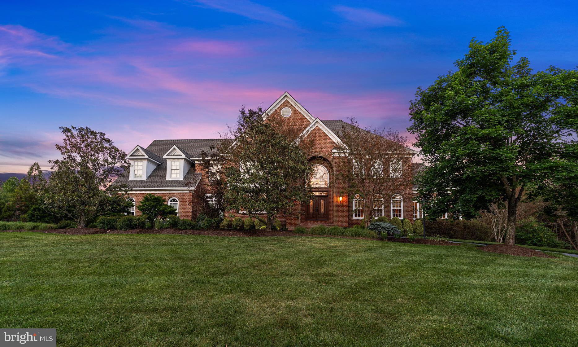 Welcome to 5452 Chandley Farm Circle — a stately brick estate situated on over 5 private acres in Sully Estates, offering 5 bedrooms, 5.5 bathrooms, and expansive living spaces designed for both everyday comfort and elegant entertaining. From the moment you enter the grand foyer, you’ll notice the home’s timeless details, elevated finishes, and one-of-a-kind designer light fixtures throughout.

The main level features an oversized dining room, formal living room, private office, and a sun-filled solarium. The impressive two-story family room showcases a striking brick fireplace and flows seamlessly into the entertaining spaces, complete with a wet bar for hosting with ease. A full bath on the main level adds additional convenience for guests. Hardwood floors extend throughout the main level, while the oversized 3-car garage provides abundant storage and functionality.

Step outside to the large deck with a gazebo area overlooking the expansive flat backyard with plenty of room for a future pool, all surrounded by the privacy and beauty of five acres.

Upstairs, the luxurious primary suite serves as a private retreat featuring a dramatic three-sided fireplace, expansive walk-in closet with dual entrances, and a spa-inspired bath with stacked stone accents. The upper level also offers oversized secondary bedrooms and beautifully updated bathrooms.

The finished lower level is ideal for entertaining and flexible living with a large recreation area, wet bar with mini fridge, designated workout room, additional bedroom, and full bath — perfect for guests, an au pair suite, or multi-generational living.