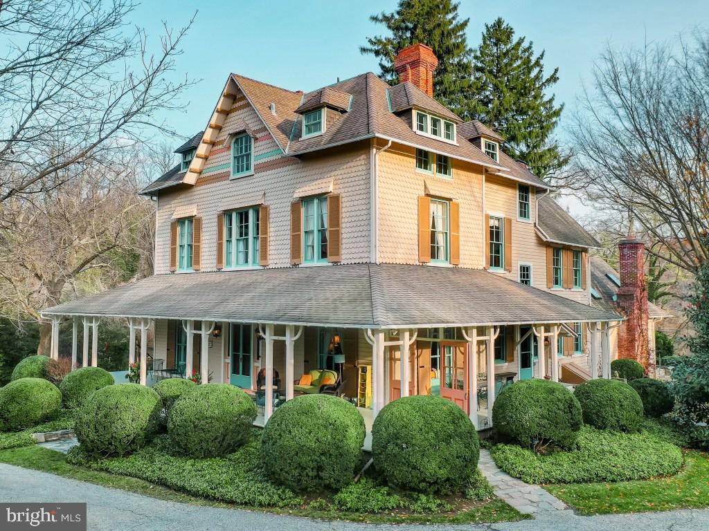 This Circa 1868 Victorian gem lies at the end of a discrete lane in Ruxton on 1.45 private acres.  Period  charm and craftmanship are apparent in the floor to ceiling lead glass windows, 8 fireplaces, original  moldings, high ceilings, heavy panel doors and pine floors.    A quintessential wrap around porch  overlooks sweeping level lawns with mature landscaping and is perfect for entertaining and quiet  relaxation on warm, summer evenings.   Enter through century old double doors into a gracious foyer  flanked by two parlors and accented by a stately 3 story staircase.  Continue to a spacious dining room,  library lined with bookcases and an eat-in kitchen.  Completing the first floor is a sun filled vaulted family room overlooking a flagstone terrace and flower gardens.  The second level includes the master  bedroom and bath, 2 more generously sized bedrooms, full bath and office/craft room. A large, sunny  laundry/utility room is also on this level.  The third floor is unique in that it is bright and airy and includes 3 ample bedrooms, a full bath, and a walk-in cedar closet.  Front and back staircases access all 3 levels.   The fully finished basement has exposed stone walls and is large enough to accommodate a home office, TV area, and exercise/play areas.   Built-in bookcases, closets, and 2 storage rooms add even more  functionality.  A detached multi story outbuilding includes a climate-controlled greenhouse and a large,  architecturally interesting storage area which could be finished as a studio, apartment or office.  The  lower level generously accommodates 2 cars and an additional storage room. A blend of privacy with the elegance of yesteryear and the convenience of Ruxton, this property is truly a rare offering and a must-see!