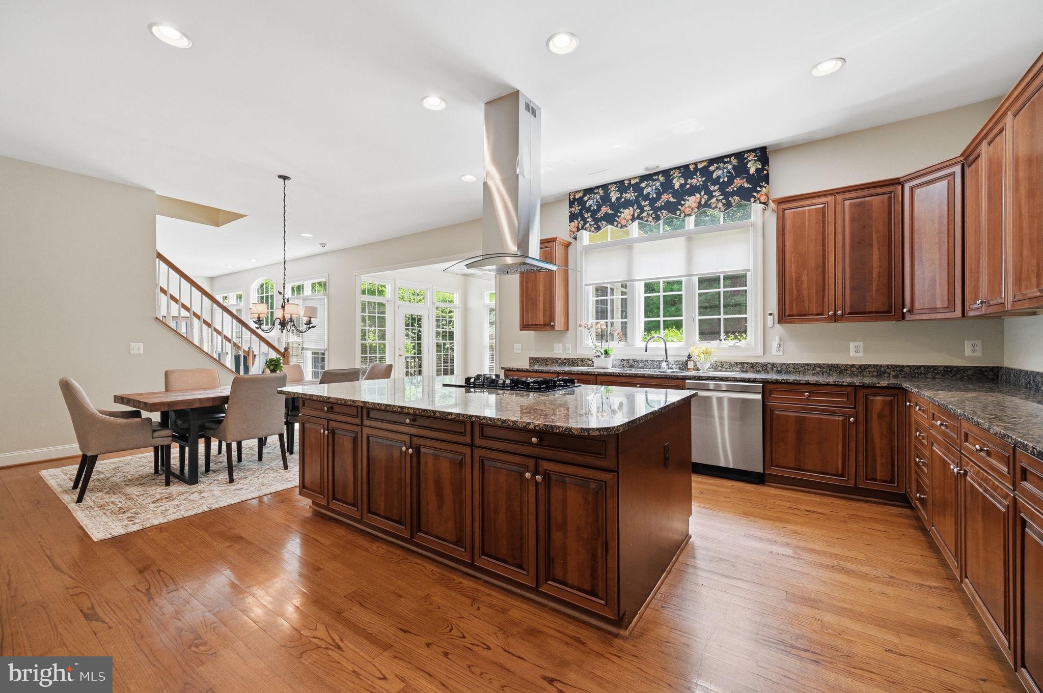 Immaculately built and beautifully maintained, this exceptional home offers an elegant blend of space, comfort, and thoughtful updates set on a private, landscaped lot designed for everyday living and memorable entertaining.

Step inside to a two-story foyer and an open, contemporary main level highlighted by hardwood floors. A bright sunroom with vaulted ceilings, ceiling fan, and abundant windows is perfect for plant lovers or a peaceful reading retreat. A private den/office with French doors makes working from home effortless, and a convenient powder room completes the main level.

The inviting t.v. room features a vaulted ceiling, plush carpet, and a gas fireplace, with windows and direct access to the deck for seamless indoor/outdoor living.

At the heart of the home is the updated kitchen. Well-appointed with granite countertops, a center island, double ovens, a dedicated microwave nook, and an oversized walk-in pantry with extensive shelving. A butler’s pantry adds additional storage and serving space. Enjoy backyard views from the kitchen window with automatic blinds, plus convenient access to the garage and laundry area. The eat-in space is accented by a statement chandelier, and the sun-filled breakfast area (Florida room-style) opens to the deck and backyard.

Formal spaces include a separate living room with wainscoting and chair rail, and a dining room with chandelier and decorative ceiling medallions, ideal for entertaining.

The three-car garage offers abundant storage and includes an EV charger (extra refrigerator in garage approx. 3 years old).

Upstairs, the luxurious primary suite impresses with a vaulted/coffered ceiling and ceiling fan, a private sitting room with gas fireplace, and a coffee station/wet bar with sink and mini-fridge area. The spa-inspired primary bath includes a soaking tub, walk-in shower, and two walk-in closets. Three additional bedrooms provide excellent closet space, one of the bedoroms with a private en-suite, plus a beautifully finished hall bath with dual vanities, honeycomb tile flooring, and a walk-in shower.

The lower level is an entertainer’s dream with a private media room (projector approx. 3 years old) and speakers, a recreation space/art room with built-ins, workout area or additional living space, guest/bonus room, full bath, and a mini bar with a large wine fridge. A private exterior entrance and abundant storage add convenience and flexibility.

Outside, enjoy a fully fenced backyard with a composite bin, mature trees, and a thoughtfully designed setting for relaxing or hosting: grill on the deck, unwind on the paver patio with pergola, gather around the fire pit, and enjoy the tranquil water feature/pond. The rear yard includes a playground area (to convey) with engineered wood fiber mulch. An underground irrigation system supports the lush landscape.. And no HOA. 
Buyer to verify dates:
Roof: 2015
HVAC: 2018
Water Heater: 2023
Dishwasher: 2023
Washer/Dryer: 2023
Outdoor improvements included a premium aluminum fence installed by NOVA Fence, a backyard playground area, improved landscaping throughout the property.
Kitchen upgrades included the installation of an island vent hood and an electric blind, along with replacement of the dishwasher. A new LG washer-dryer unit for the laundry.
The living area was updated with modified wood cabinetry to accommodate a larger TV.
New King mattress with electric adjustable base.
All five bathrooms were upgraded with the addition of bidet sprayers.
Basement upgrades included new carpeting (for main area) and replacement of the water heater. Additional interior enhancements included updated paint in select areas. Media room upgrades included a new projector and main speaker.
Garage upgrades include blinds and smart garage
About $70,000 in recent home improvements, upgrades, and enhancements. Furniture, including  a Baker dining set (originally purchased $20k), will be included at no additional cost with an acceptable offer.