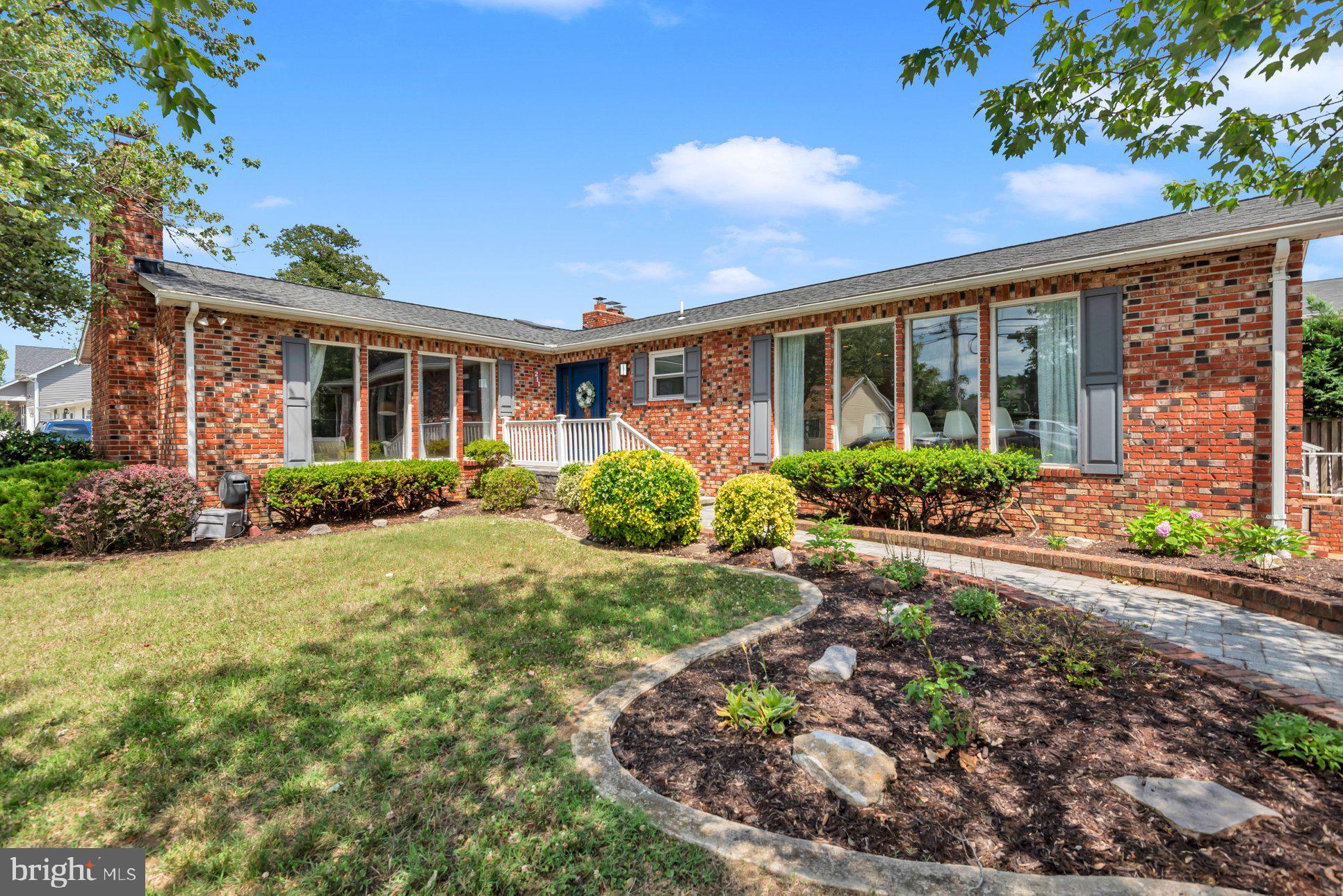 Tucked just off Poplar Trail, 211 Pindell Avenue is a classic brick rancher that lives far larger than expected—4,497 square feet of light-filled, entertainer-ready space waiting to be enjoyed.

Inside, walls of oversized windows pour sunshine across hardwood floors and custom trim. The living room rises to a vaulted ceiling anchored by a wood-burning fireplace, while the dining room charms with a beamed ceiling and cozy woodstove. Multiple fireplaces throughout boast dramatic floor-to-ceiling brick fronts and hearths, adding warmth and character to every gathering.

The 2024-renovated kitchen is a true centerpiece, featuring stainless steel appliances, granite countertops, a tile backsplash, high cabinetry, recessed lighting, and a center island with seating. A sunny Florida room and a great room with built-in bar extend the home's effortless flow.
Retreat to the primary bedroom, complete with refinished hardwood floors, a walk-in closet, sitting area, and en-suite bath. Downstairs, an expansive finished lower level features a den and bonus room —each with its own wood-burning fireplace and a game room.

Recent upgrades include new windows in 2023, a fence in 2024, a French drainage system, an EV charger, Ubiquiti WiFi, and fully rebuilt chimneys. A two-car garage and spacious paver driveway complete the package.

The location shines: close to Navy Stadium, downtown Annapolis, City Dock, the State House, and the Arts District. Boutiques and fine dining moments from your door.  In close proximity to Washington, DC and Baltimore.  This is Annapolis living at its best!