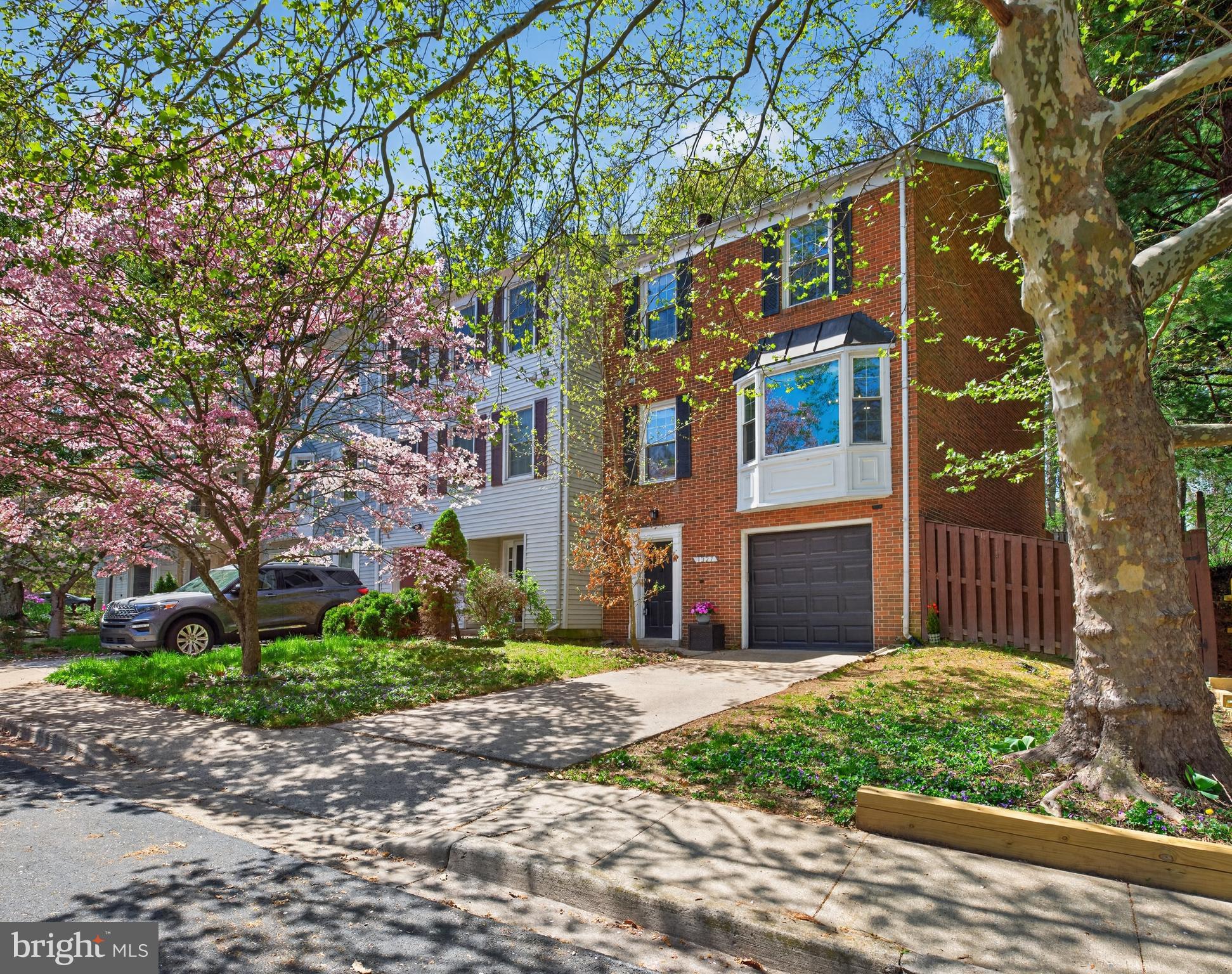 Beautifully updated and meticulously maintained, this 3-bedroom, 3.5-bath end-unit townhome in the desirable Woodland Hills community offers exceptional natural light, thoughtful updates, and flexible living spaces across three finished levels. The main level is filled with abundant natural light from every angle and is enhanced by recessed lighting and rich hardwood floors that flow seamlessly throughout. The kitchen is a true delight, featuring white shaker cabinets, a classic white subway tile backsplash, granite countertops, and stainless steel appliances, including a newer dishwasher and refrigerator, both replaced in 2024. A breakfast peninsula and charming breakfast nook provide the perfect space for casual dining, while a large bay window overlooks the front lawn and frames beautiful views of mature trees and seasonal spring blooms. Just beyond, the spacious living and formal dining areas create an inviting setting for both everyday living and entertaining, highlighted by a wood-burning fireplace with a beautiful stone surround, built-in shelving and cabinetry, and direct access to the rear deck for effortless indoor-outdoor enjoyment. An updated powder room and laundry closet with newer washer and dryer (2024) complete this level. Retreat upstairs to the stunning owner’s suite, complete with its own wood-burning fireplace, three spacious closets, and an updated en-suite bathroom featuring a dual-sink vanity and tiled walk-in shower. Two additional generously sized bedrooms share a hallway bath with gorgeous tile work and a tub/shower combo. The walkout lower level offers additional living space in a large flex room with closet space and a full bathroom, ideal for a guest suite, private home office, or kid’s playroom. Step outside to the rear yard, complete with a deck, paved patio, and fenced-in yard, providing a peaceful outdoor retreat to enjoy wooded, tree-lined views with no rear neighbors. An attached one-car garage and driveway offer off-street parking for up to two vehicles, plus ample open parking throughout the community. Additional recent updates include a new roof (2023) and HVAC (2024). Enjoy community amenities including a pool, tennis courts, and playgrounds, along with an excellent location close to shopping, recreation, Gaithersburg MARC, and major commuter routes.