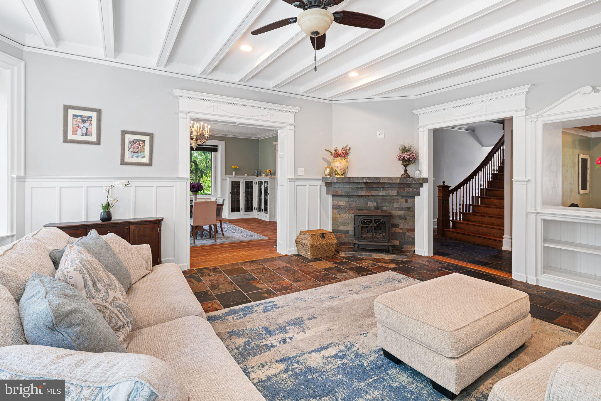 Welcome to 112 W Upsal Street, a remarkable 1916 Center Hall Victorian-inspired estate tucked into the heart of the highly sought-after West Mount Airy neighborhood. Set on a rare and private 0.6-acre lot, this extraordinary stone residence offers approximately 5,479 square feet of living space with 7 bedrooms and 5.5 bathrooms, seamlessly blending historic character with thoughtfully integrated modern updates. From its stately exterior and wrap-around porch to its lush, fenced grounds filled with organic gardens, rain gardens, a greenhouse room, and expansive outdoor entertaining spaces, this property delivers a truly one-of-a-kind retreat within the city.

Step through the grand original entry into an impressive center hall where refinished hardwood floors, slate accents, soaring ceilings, and stunning period craftsmanship immediately set the tone. A fully equipped saloon with a wine fridge, beer cooler, sink, and dishwasher creates the perfect entertaining space, while the elegant formal dining room showcases original built-ins, a fireplace, and inviting gathering areas designed for memorable occasions.

At the center of the home is the beautifully updated eat-in kitchen featuring a dual-faucet farmhouse sink, tiled backsplash, stainless-steel dishwasher, gas range with double oven, oversized commercial-grade refrigerator/freezer, and built-in farm table. The kitchen flows effortlessly into the warm and inviting family room with exposed beams and a gas fireplace. Just beyond is a private in-law suite with exterior access, complete with a mini kitchen, full bath, and flexible living and sleeping quarters—ideal for guests, multigenerational living, or income potential.

The upper levels continue to impress with five spacious second-floor bedrooms, including three ensuite layouts, multiple fireplaces, renovated baths, and a conveniently located laundry room. The third floor serves as a luxurious private retreat, featuring a stunning primary suite with vaulted ceilings, an expansive custom walk-in closet, a spa-inspired bath with dual vanities, a wet sauna,  and an oversized walk-in shower. An additional bedroom currently serves as a home office, offering flexibility for evolving needs.

Modern improvements—including split-zone HVAC, PEX plumbing, updated electrical, newer wood double-pane windows and roof, and a Nuvo 5-zone audio system, waterproofed basement—provide peace of mind while preserving the home's historic integrity. An extended driveway offers generous off-street parking, with space for a future carriage house or garage. 

West Mount Airy stands as one of Philadelphia’s most cherished communities, offering a rare blend of urban convenience and suburban tranquility. Enjoy a strong sense of community, rich diversity, exceptional access to nature via the nearby Wissahickon Valley Park with its extensive hiking trails, convenient commuting to Center City, local co-ops like Weaver’s Way, vibrant shops and eateries, and a welcoming atmosphere that perfectly balances city energy with natural beauty. From the moment you enter, 112 W Upsal Street feels like a true sanctuary—grand yet livable, historic yet fully updated, and perfectly situated in one of Philadelphia’s most desirable neighborhoods. This is more than a home; suburban inspired living at its finest yet in the city—elegance, space, community, and endless possibilities await.