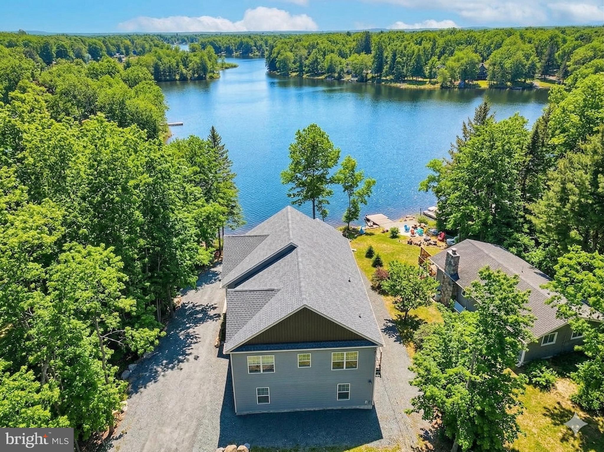 Welcome to Sunset Horizon, a fully amenitized, newer construction, turnkey lakefront retreat in the highly sought-after and STR-friendly Arrowhead Lakes community—a rare combination of prime location, guest experience, and income potential.

This true lakefront property delivers the full waterfront lifestyle, featuring unforgettable views and a strong amenity package, plus an additional 600+ sq ft unfinished space currently being completed, offering a blank canvas for future value-add features.

Set yourself apart from the competition with premium outdoor features including private lake access, an expansive deck overlooking the water, a hot tub with lake views, fire pit for year-round enjoyment, and covered outdoor dining—all designed to enhance guest experience and drive bookings.

Spanning approximately 3,400 sq ft, the home offers 5 bedrooms and two oversized bonus rooms, providing ample space for large groups, events, and high-revenue stays.

Originally designed by an owner/architect with both experience and revenue in mind, the home features a bright, open-concept layout with vaulted ceilings and panoramic lake views, creating a warm yet elevated mountain-lake aesthetic.

The spacious living and dining areas are ideal for entertaining, while the fully equipped kitchen easily accommodates large gatherings.

Flexible sleeping arrangements—including king suites, a bunk room, and additional guest rooms—maximize occupancy and booking versatility.

This property features two large bonus spaces, designed to keep guests engaged year-round. The lower level includes a fully equipped game room, a major driver for family and group bookings.

An additional space—currently being converted from the garage—offers the opportunity to create custom, high-impact amenities such as an indoor pool, private theater, or wellness space, allowing you to further increase revenue potential. The indoor pool and movie theater are virtually staged with potential ideas. 

Located within Arrowhead Lakes, guests enjoy access to 3 community pools, 4 beaches, tennis, basketball and volleyball courts, a playground, lodge, and fitness center, enhancing the overall guest experience and booking appeal.

Whether you're seeking a cash-flowing investment, a hybrid vacation home, or a lifestyle property that delivers both enjoyment and returns, this lakefront retreat checks every box.

Lakefront properties with this level of size, amenities, and income potential rarely come to market—don’t miss the opportunity to own a true top-performing asset in the Poconos.