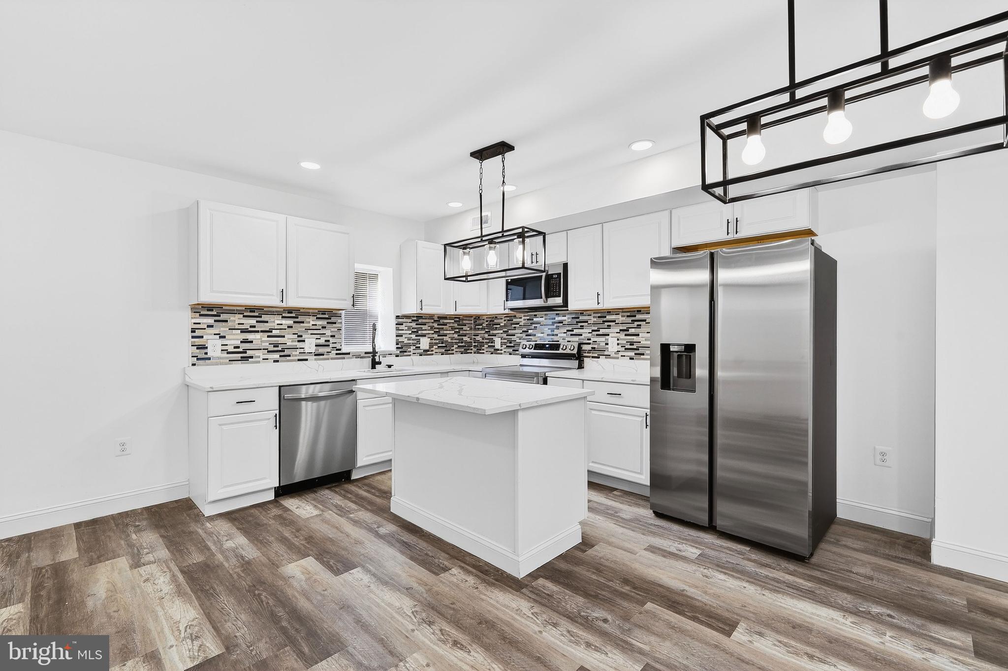 Welcome to luxury living in Baltimore City! Step into a beautifully renovated 5-bedroom 4-bath home in Baltimore, where every detail has been meticulously crafted for modern living. This home has been remodeled and upgraded from top to bottom, with all required permits pulled with Baltimore City. This move-in-ready home features brand-new stainless steel high-end appliances, a new HVAC system, new water heater, new windows, and a new roof, giving you peace of mind for years to come.  With its inviting front front, this charming residence boasts 5 spacious bedrooms and 4 bathrooms, including a master suite on the second floor with a stunning standing shower. Kitchen is stacked with high-end fixtures, energy-efficient appliances, and an open floor plan to create an atmosphere of luxury and comfort. The chef-inspired kitchen features stainless steel appliances, sleek quartz countertops, a 5-burner electric stove with an over-the-range microwave, a custom backsplash, and an energy-efficient Samsung refrigerator. The main level offers a generously sized living and dining area, a powder room, and an exterior door leading to a private deck - perfect for Summer entertainment. Upstairs, you'll find three large bedrooms, each serving as a peaceful retreat from the hustle and bustle of daily life. The master suite is truly a sanctuary, complete with an elegant en-suite bathroom. The fully finished basement adds even more living space, offering endless possibilities. With two additional bedrooms, a full bath, and a recreational area, the basement is ideal for hosting guests, creating a home office, or potentially generating rental income. It’s the perfect balance of functionality and flexibility. Basement rooms can be converted into a home gym, or recreational area, allowing for further customization. The backyard is fully fenced for added privacy, and the deck provides the perfect space for outdoor entertaining or enjoying Summer activities. This home truly exceeds expectations with its impeccable renovations and unbeatable location. Located just outside the heart of Baltimore, this home is only minutes away from downtown, offering a wealth of dining, shopping, and entertainment options. Right next to MARC train station (West Baltimore Station) and very close to tons of attractions/landmarks including the Baltimore Port, M & T Stadium, Horseshoe Casino, Johns Hopkins Hospital, and more. By completing Baltimore City homeownership counseling, buyers may qualify for various grants and down payment assistance programs—be sure to check eligibility with your lender. Don’t miss out on this extraordinary opportunity to own a luxurious home in a prime location!