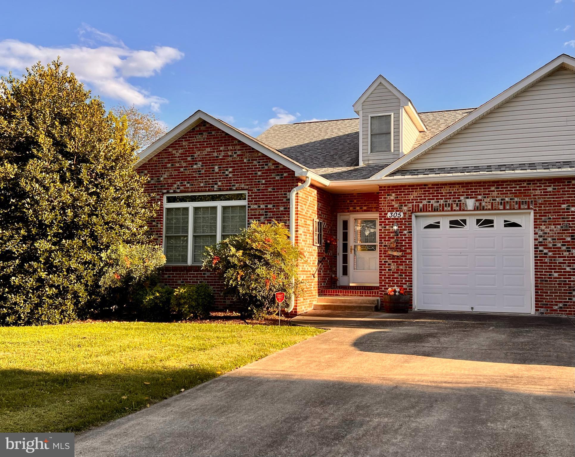 Welcome Home to 305 Brookline Drive! Spacious, bright, and airy mixed with a little bit of luxury, this gorgeous villa in highly sought after Locust Hill is just what you’re looking for – and you’ll have a beautiful view of the 10th Hole of Locust Hill Golf Course! This lovingly cared for, one owner home has 3 bedrooms, including an upstairs that includes a bedroom with a very generous separate closet and full bath. The expansive primary suite is conveniently located on the main floor and includes a luxurious en-suite bathroom with separate jet tub, glass-door walk-in shower, and a separate, additional wall heater that will make getting ready for the day extra cozy! The home is also adorned with gorgeous wood flooring, beautiful crown molding, and plush carpet throughout. The kitchen offers a long breakfast bar, beautiful cabinetry, and a butcher block-topped island, and the dining area just off the kitchen is filled with light. Moving on from the kitchen, you’ll find a spacious living room with a beautiful propane-fueled fireplace and, beyond that, an additional expansive sitting room that leads to the French doors to the back deck, where you’ll find that gorgeous view!  If it’s room to spread out you’re looking for, this home with its over 2,550 square feet, is THE ONE!!