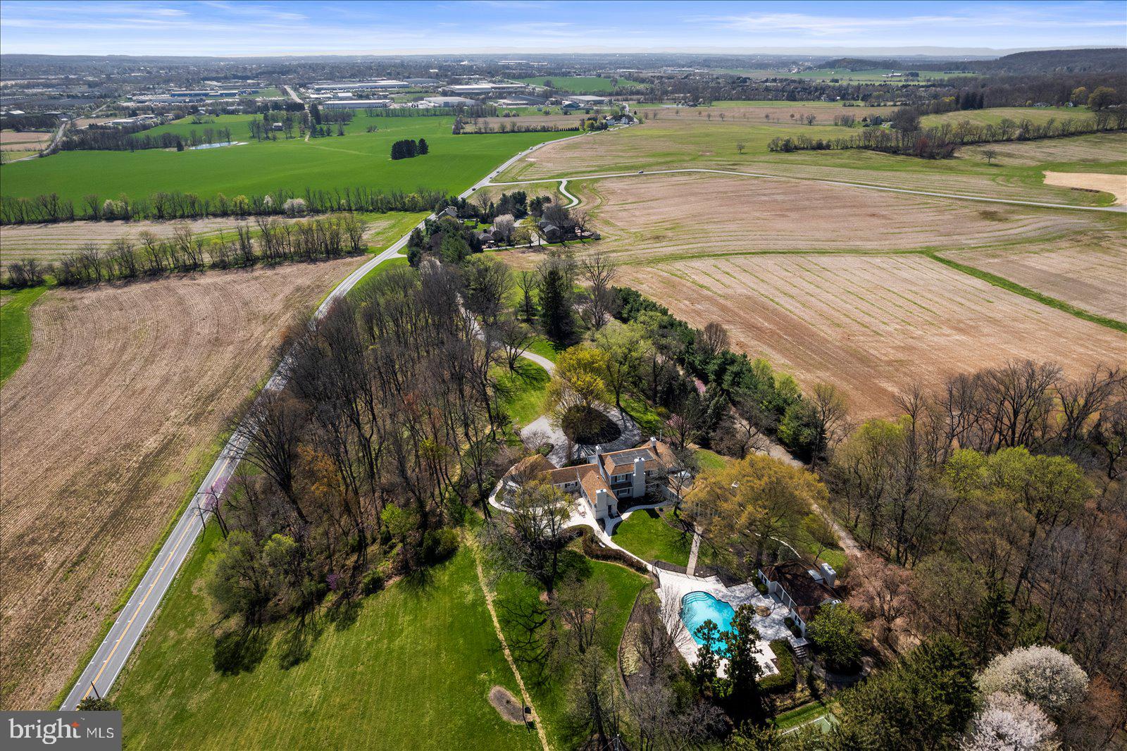 If you value privacy, exquisite views and a resort lifestyle, then look no further as this regal estate, high on the hill is sure to please!  With attention to every detail, this property presents an unmatched level of impeccable design. Enter through a gorgeous masonry pillared gate and be impressed by the tree-lined entryway as you are greeted with breathtaking views that go on for miles. Luxury exudes all around you on this 10+ acre, resort-style residence. An expansive renovation of the entire property showcases this one-of-a-kind custom property for one with distinguished taste. Enter through the double doors to the grand two-story foyer featuring two closets and a settee. Go upstairs and discover two bedrooms complete with walk-in closets and a full bath or continue on the first floor to the massive main living room area with exposed wood beams, a fireplace with beautiful stonework and even a wet bar to service this room. Follow the French doors to the dining room and discover the wall of windows with the extensive, scenic views on full display. Here you will also find a multi-level outdoor terrace, with landscaping to complement the round paved terrace leading to the pool.  Also in the dining room is a bar pass-thru and plenty of room to entertain noted by the oversized dining room table. The kitchen boasts beauty and grandeur that any chef would love. With a portable island, ss appliances and an imported backsplash from Italy, this bright and welcoming kitchen will make creating dinners a delight. The first-floor primary ensuite features 4 closets, 2 sinks, a vanity, dual shower heads, soaker tub, linen closet, and a separate WC. A delightful office space with built-ins and a powder room across the hall make the owners wing a private, personal space. Stroll down the hall to the East Wing and on your way find the meditation room. Here you can enjoy your morning workout with a large fountain, plant life, a 6-person sunken hot tub and powder room. There is a massive dome style skylight above that adds plenty of natural light or enjoy your evenings to gaze at the stars when you wind down from a long day. Continue down the hall to find a French-styled Great room, fit to impress! With 16’ ceilings this spectacular space knows no limits with the enormous fireplace, built-ins, wet bar, mini fridge, motorized cabinet lift TV, stunning chandelier (also on an electric pulley system) and massive windows framing the French doors to the terrace. There is ambiance at every turn of this residence, and the China Room is just one more example. This is a great place for afternoon tea, to host a luncheon, or to enjoy a great novel on the bench seat by the large bay window. Do you enjoy gardening? There is an attached greenhouse with Humidistat/Thermostat; it is a true horticulturists delight! The pool house features a stunning white stone fireplace, water skid-safe ceramic tile floor, skylight, soothing color palate, open-air concept and everything needed for perfection in entertaining as well as two, twin bedrooms!  Be sure to visit the newly resurfaced pickleball court with stunning views and after a game relax those muscles in the sunken, outdoor hot tub or take a dip in the heated 50,000-gallon pool, with dive. This property offers dream-worthy outdoors, mature landscaping and vista views that are unending! There is parking overflow for 26 cars. With just over 10 acres this property is Clean & Green. The main house is a total of 7,249 sq feet. The pool house is a total of 2,561 square feet. Both have been freshly painted to offer a heartfelt welcome to you and your guests. There are 5 bedrooms and 5 baths between both properties.  Location Location Location.  This Estate is like no other. Come and live your best life, every day, on the hill at 6759. Please note: Shown furnished. Furniture does not convey.
