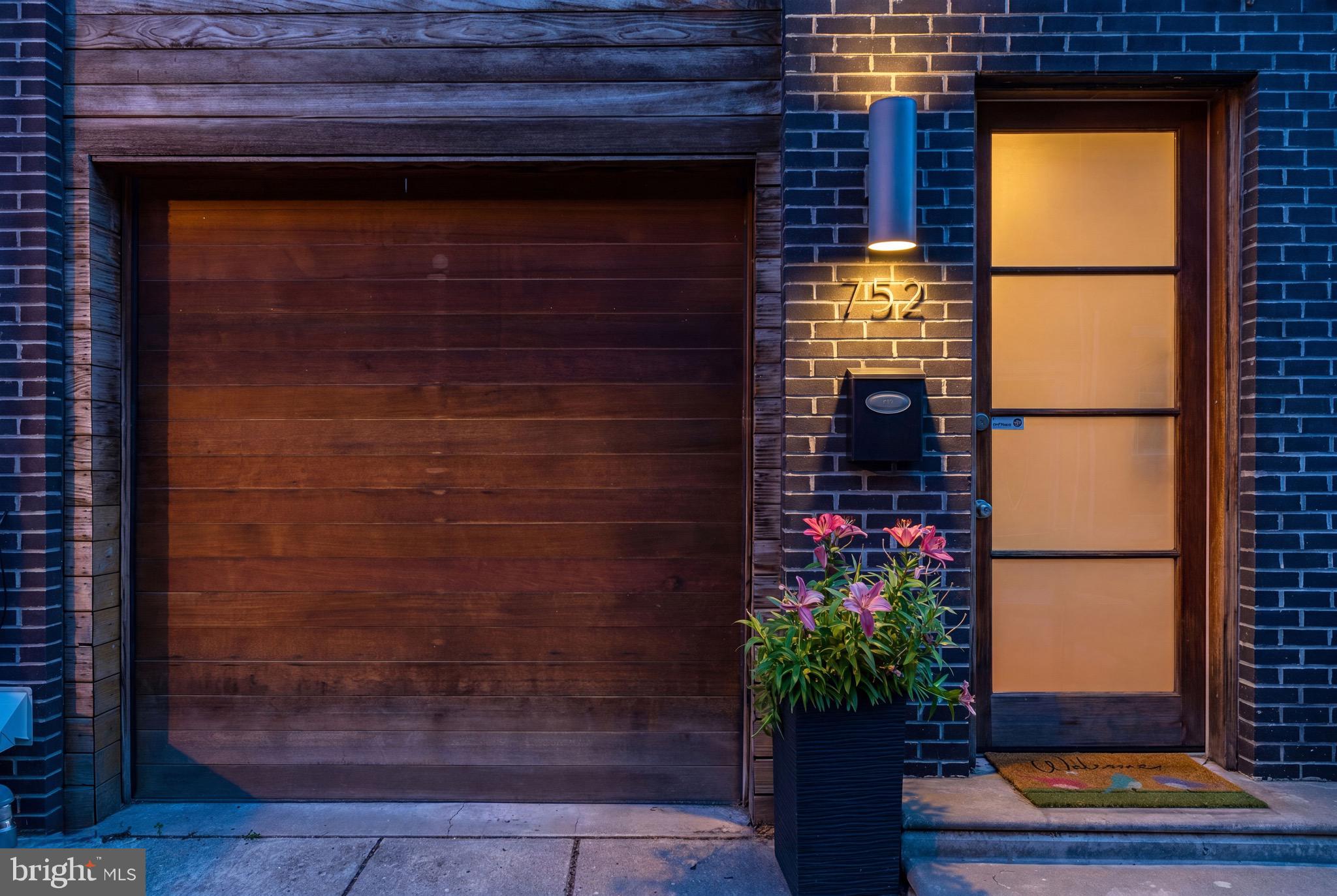 Tucked away on a quiet side street​ in Graduate Hospital, this architectural contemporary townhome ​with a one-car GARAGE, masterfully pairs sleek modern design with low-maintenance luxury. From its striking curb appeal to its ​b​eautiful finishes, every detail of this residence was thoughtfully curated. Finding a premier location with a private garage for under $1 million is a rare feat.

At the heart of the home, the main living level showcases a culinary kitchen centered around a waterfall-edge quartz island, premium stainless appliances, and a gas range. Expansive, floor-to-ceiling sliding glass doors dissolve the boundary between indoors and out, opening to a private retreat perfect for alfresco dining.

The upper levels host peaceful, oversized bedrooms paired with spa-caliber bathrooms—one featuring a deep soaking tub and the other a frameless glass shower, both accented by floating vanities and timeless tilework. ​You wont want to miss the expansive private roof deck, offering panoramic city views and an unmatched backdrop for twilight entertainingBelow, a finished  basement offers the ultimate flexible footprint for a home office, gym, or au pair suite, complete with a full bath and dedicated laundry. Rich hardwood floors, recessed lighting, and abundant storage complete this rare urban sanctuary.