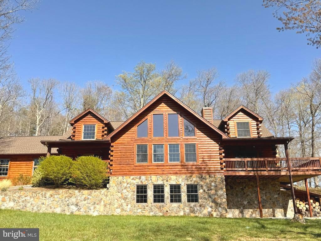 Sellers accepted offer sight unseen. Would look at back up offers. This five bedroom, three-and-a-half bath estate located in Berkeley Springs is perched atop a mountain on ten wooded acres acres near Cacapon State Park. Private and secluded, this 4000-square-foot custom-built home with a 32X28 double car garage has expansive mountain views—plenty of land to explore—and room to grow. Possibilities abound on the land for a garden, a vineyard or even stables.
The home has been lovingly maintained and updated by the current owners (only the second family to live there) both inside and out. The entire exterior of the home was stained after extensive repairs were made to the log exterior. In April of 2024, a new GAF roof was installed with a 50-year transferable warranty (see attached docs for warranty details). Gutter guards were installed; the driveway was updated and recoated; the concrete patio was reinforced and upgraded. The entrance to the home is welcoming and once inside, the massive stone, wood-burning fireplace at the center of the home is in your line of sight, eclipsed only by the wall of windows overlooking the mountains. Luxury vinyl plank flooring covers the main level (practical for this type of living) with the exception of the newly added hardwoods in the primary suite. 
The open floor plan allows for easy entertaining from the gourmet kitchen (stainless steel appliances, an induction cooktop, hickory cabinets, quartz countertops) Not only is there tons of cabinet space and an additional smaller pantry, but there is a massive, butler's pantry plus laundry room with even more room to store, prep and execute events in the dining and living space or out on the patio off of the dining room with a natural stone fire pit. The hallway off the kitchen provides access to the butler's pantry, basement and garage, as well as the half bath and the office with custom built-in bookcases.
The primary suite is on the main level with an en suite bathroom; a massive walk-in closet with a built-in Sentinel gun safe; and french doors creating a private entrance  to the mountain view deck. The primary bathroom is a suite unto itself! It has two vanities with granite countertops and ample storage;  faucets in oil-rubbed bronze; a stall shower; and a huge jetted tub surrounded by windows, light and views of nature. 
The upper level mezzanine overlooks the living room and sits opposite the wall of windows and has its own seating area located centrally between the four bedrooms and two bathrooms upstairs. Two of the bedrooms have massive walk-in closets with wall safes permanently installed. 
Tucked away out of site in the lower level is a bonus room—the ultimate man cave—a 230-square-foot finished space that works perfectly as a media room, bar room or cigar lounge. Plenty of room to add a wine cellar, root cellar or storage for emergency provisions. 
If you love to have the possibility of customizing raw space, perhaps building out an in-law or caretaker suite or even a rental apartment, the lower level provides 2000 ft of raw space with full daylight and a separate walk-out entrance with rooms already framed as well as rough in plumbing  to continue your vision.  This house is strong and efficient with the systems primarily in the lower level—including the heat pump, wood furnace, 50 gallon water and the newly-installed (2025) water softener and treatment system including reverse osmosis drinking system. There's back-up power via a generator transfer switch in the garage (you supply the generator)
