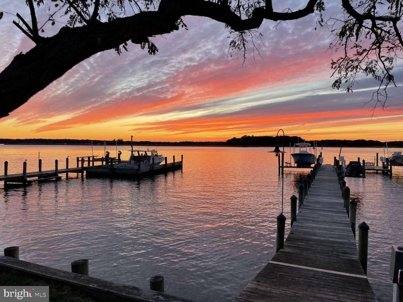 Professional pictures coming! Gorgeous Waterfront property on Cox Creek with stunning sunset views. Open house Friday June 19, 7:00-8:30 PM for sunset viewing This cottage-style retreat on Cox Creek offers the perfect blend of cozy charm and luxury living. Featuring a refreshing pool (grandfathered in the 100 foot buffer) with 180 degree views, fully equipped gym, 4 garage spaces, dock with 2 boat lifts and jet-ski lift, a versatile guesthouse with full kitchen that sleeps 8, and an outdoor kitchen with Italian pizza oven and Evo grill! The property provides panoramic breathtaking sunset views over the water which makes it the perfect Home for those looking for the ultimate Eastern shore lifestyle! The charming main house, renovated in 2022, with its huge wrap around porch and cozy screened in porch, boasts 3 bedrooms and 3 full baths, expansive windows, high end finishes, custom moldings, and unobstructed water views. The guesthouse, built in 2021 with Full kitchen, living room, and 2 bedrooms and bath, blends character and luxury offering an inviting space with beautiful water views. It comfortably sleeps 8 with king bedroom, and bunk-bedroom with built in bunks. Reclaimed wood floors provide character, blending with the crisp white board-and-batten walls, wood ceilings, and elegant wainscoting molding. Included is a fitness gym featuring top-tier equipment built for rigorous training, and the water views inspire every workout. Guest house was used as a short term rental, generating extra income. The oversized in-ground pool has been extensively renovated to create a true resort-style outdoor experience. Major improvements completed in 2021 included new pool equipment, new plumbing and electric, new tile, a premium pool deck, and sun shelf. Newly resurfaced in 2026 provides years of beauty and enjoyment. Designed for both relaxation and recreation, the pool features an in-water sun shelf with integrated mounts for umbrellas, tables, and seating. Perfectly positioned to capture panoramic Cox Creek views and spectacular sunsets, this exceptional pool setting serves as the focal point of the property’s outdoor living and entertaining spaces, delivering a waterfront resort experience. The guest house is enhanced by a three-car garage configuration consisting of an attached two-car garage and single-car garage, providing exceptional space for vehicles, recreational equipment, and storage. Built-in shelving and storage racks accommodate kayaks, bicycles, and other outdoor gear, making the space ideally suited for an active waterfront lifestyle. In addition, the property includes a separate detached single-car garage offering outstanding flexibility for vehicle storage, a workshop, hobby area, or storage of landscaping and maintenance equipment. The detached garage is equipped with dual 30-amp, 240-volt camper receptacles with weather-protected in-use covers, providing convenient power access for recreational vehicles, trailers, or specialty equipment. Together, these garage facilities provide four enclosed garage bays and abundant storage capacity for vehicles, boats, water toys, outdoor equipment, and workshop needs. The Outdoor kitchen is positioned to capture unobstructed panoramic sunset views of the water, featuring a gas fired Alfa Pizza Oven and a flat top circular EVO cooktop. Its teppanyaki style flattop allows you to sear scallops, stir fry vegetables, or smash burgers facing the water. The private dock with a large over-water entertainment platform, electric, water, decorative lighting, two Magnum boat lifts with remote control, personal watercraft lift, and spectacular western-facing sunset views over Cox Creek. This *must see* home is more than just a house, it's a lifestyle. This property is custom built for family gatherings, entertaining, and endless outdoor recreation: Swimming, Boating, Jet-skiing, Kayaking, Paddle boarding, Yard games, Crabbing and Fishing off the dock, Biking and Pickle ball!