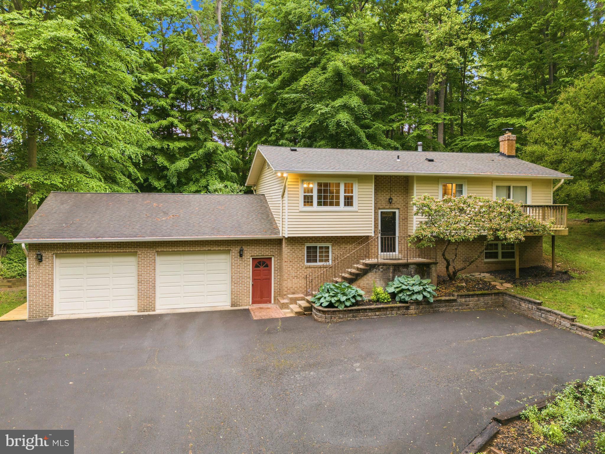Escape to your own private oasis in the woods! This unique property includes two parcels totaling over 2.36 acres. Please note: 8016 Lake Drive consists of 1.3386 acres and includes the existing home. 8014 Lake Drive consists of 1.0274 acres, fronts the road, and may allow for the construction of a second home.

This spacious single-family home features 4 bedrooms, 3 full updated bathrooms, and an open-concept floor plan. The kitchen offers Corian countertops and stainless steel appliances. Hardwood floors run throughout the living room, hallway, and main level bedrooms. The living room features skylights, and crown molding can be found throughout the home. Fresh neutral paint adds a bright, updated feel.

The main level includes 3 bedrooms and 2 full bathrooms. The lower level features updated luxury vinyl plank flooring, a large family room with wood stove, 4th bedroom, and 3rd full bathroom.

Enjoy peaceful wooded views from the screened-in porch overlooking the scenic backyard, complete with a large deck and hot tub. The attached 896 sq. ft. 2-car garage includes a workshop area and abundant storage, plus an additional 3-car carport on the side of the home. Two storage sheds convey. Roof, siding, and gutters were replaced in 2011. No HOA!