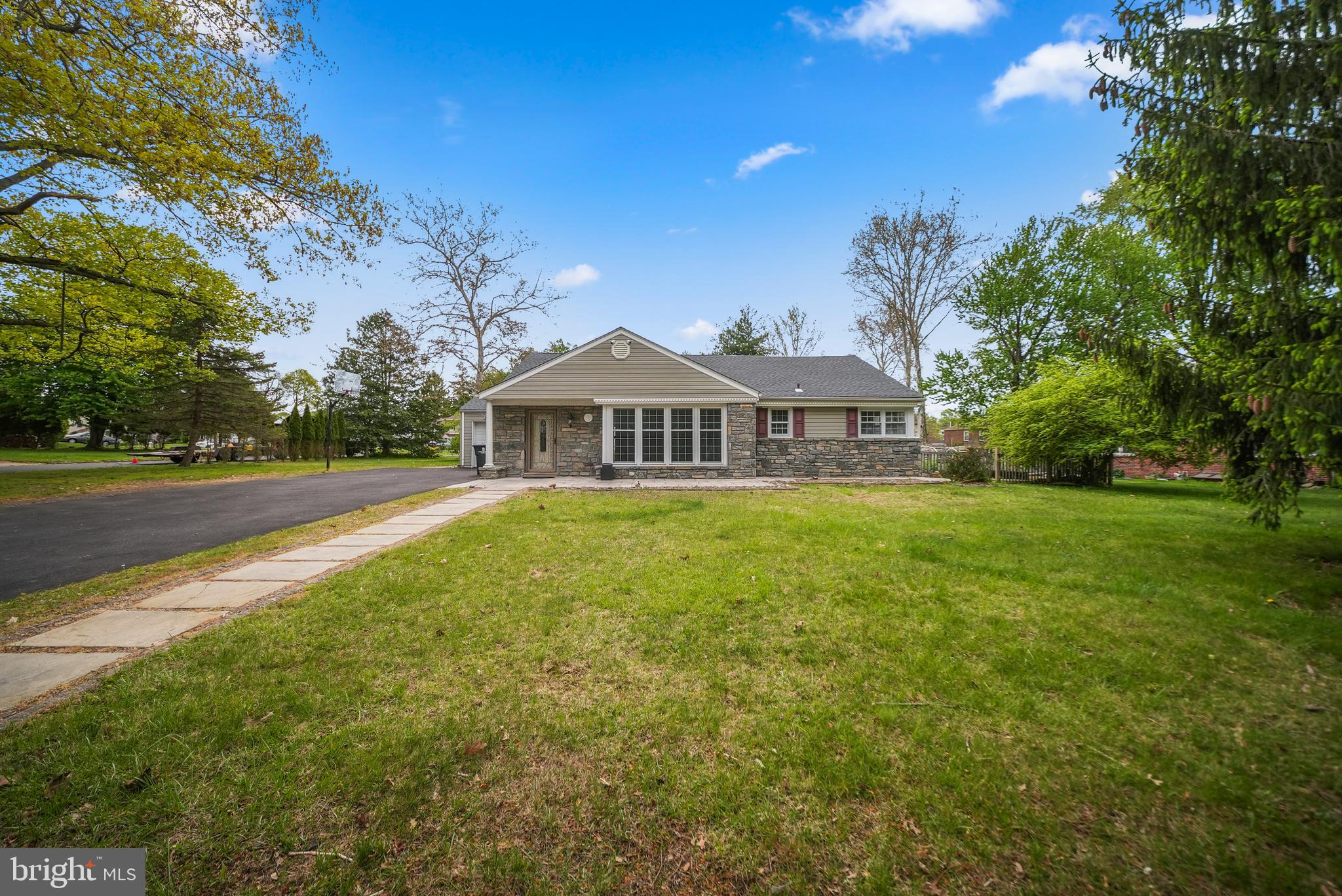 Nestled on a serene corner lot within the prestigious Lower Moreland School District, this impeccably updated residence offers the ultimate in sophisticated one-floor living, combining a bright, airy open-concept layout with high-end designer finishes throughout. The heart of the home is a stunning chef’s kitchen equipped with professional-grade KitchenAid stainless steel appliances, crisp white shaker cabinetry, and elegant quartz countertops that wrap around a central kitchen island—the perfect hub for morning coffee or casual evening entertaining. This culinary space flows effortlessly into the dedicated dining area and a spacious, sun-drenched living room, creating a seamless environment for both relaxation and social gatherings. Retreat to the luxurious primary suite, which features an expansive, oversized custom shower designed for a spa-like experience, while two additional main-floor bedrooms provide comfort and versatility. A unique spiral staircase ascends to a fully finished attic complete with a private half-bath, offering a flexible space ideal for a fourth bedroom, secluded home office, or guest quarters. The interior transitions beautifully to the outdoors through sliding glass doors that lead to an expansive rear deck and a meticulously laid paver patio, providing an ideal backdrop for outdoor dining overlooking the lush grounds. Additional highlights include a heated and nicely finished one-car garage with convenient deck access and a prime location just a two-minute stroll from the playground, tennis courts, and peaceful walking trails of Ridgeway Park.