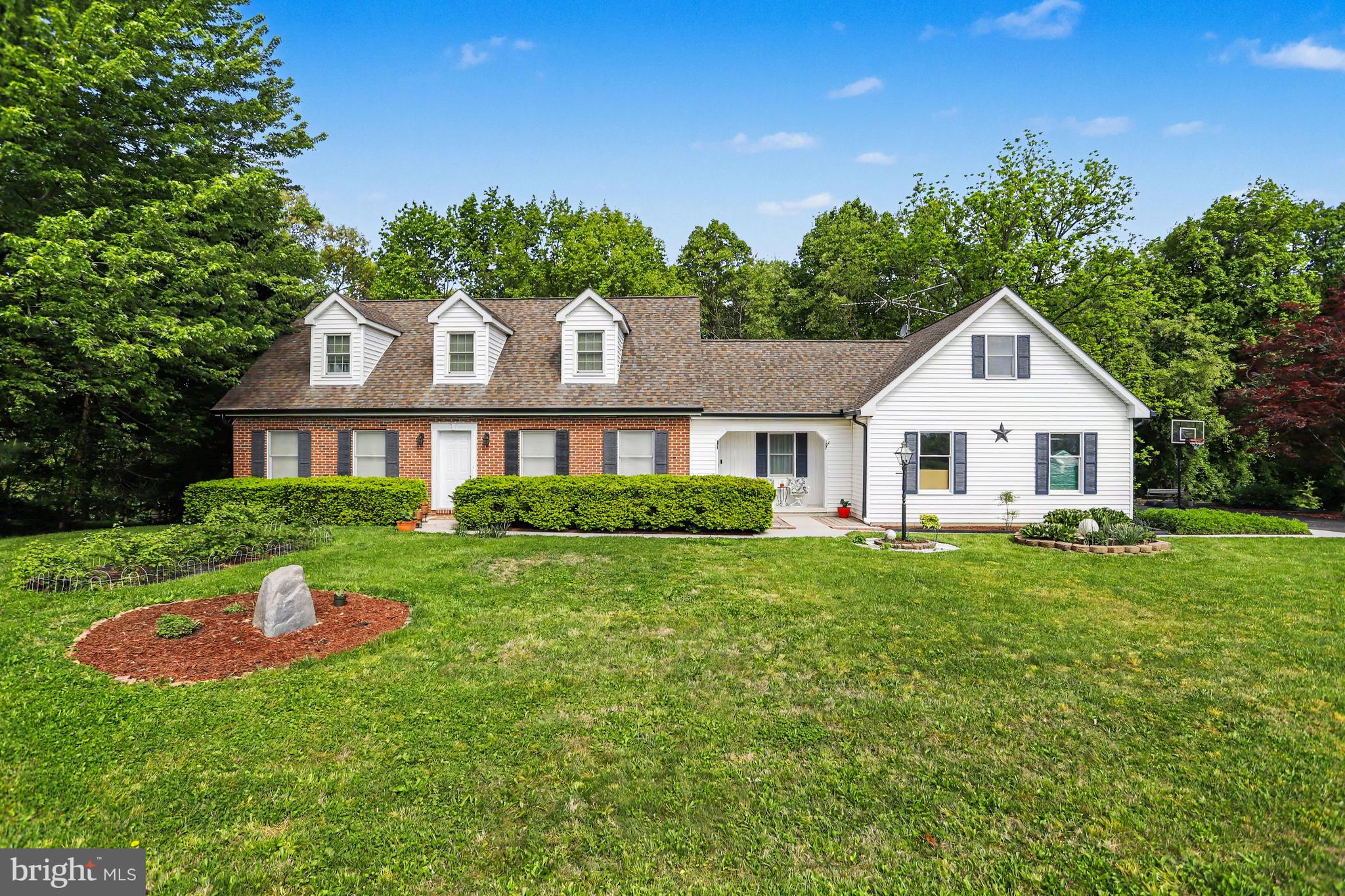 Nestled on a picturesque .94-acre lot backing to mature woods in desirable Carroll County, this charming Cape Cod offers the perfect blend of privacy, comfort, and convenience. With 4 bedrooms, 2.5 baths, and a flexible floor plan featuring two bedrooms and a full bath on the main level along with two additional bedrooms and another full bath upstairs, this home is ideal for a variety of living arrangements.  The spacious kitchen is designed with both everyday living and entertaining in mind, featuring a center island, a second prep sink, abundant cabinetry, and all appliances included. Formal living and dining rooms provide elegant gathering spaces, while the dining room opens to a large rear deck overlooking the peaceful wooded backdrop perfect for hosting family and friends or simply enjoying the tranquility of nature. A welcoming covered front porch adds even more outdoor living space and enhances the home's timeless curb appeal.  The fully finished basement expands your living area and includes a convenient half bath, along with a wood stove that is ducted into the HVAC system to provide supplemental heat and improved energy efficiency. A pellet stove on the main level offers additional warmth and charm during the colder months. Additional highlights include an attached two-car garage, new in 2024 is a 20x8 storage shed that provides ample space for lawn and garden tools, outdoor equipment, and seasonal storage, and a new HVAC system installed in 2018 for added peace of mind.  Conveniently located close to schools, shopping, dining, and parks, with easy access to both Baltimore and Pennsylvania for commuters, this beautiful property combines country charm, modern comfort, and an unbeatable location. Don't miss the opportunity to make this peaceful retreat your next home!