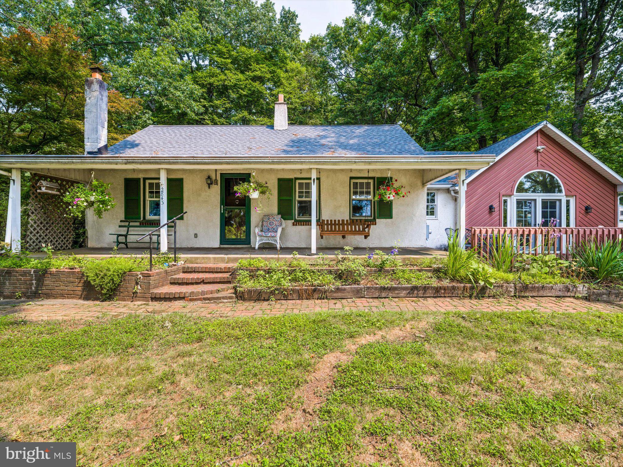 Peaceful setting elevated above the beaten path. Beautiful hardwood floors flow throughout much of the home, creating warmth and timeless appeal. The spacious family room features a charming brick wood-burning stove and opens directly to a deck, making it perfect for relaxing or entertaining. The covered porch is truly relaxing. The functional floor plan includes a separate laundry room and a convenient first-floor primary suite with a full bath. Step down to the oversized 3-car garage, which provides direct access into the home. Major updates provide added peace of mind, including a newer roof (approximately 6–7 years old), HVAC system (3 years old), and hot water heater (2 years old). This well-cared-for home offers comfort, space, and lasting value in a desirable, established location.