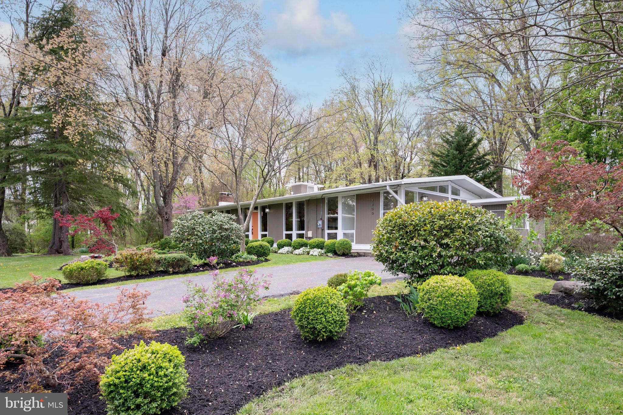 This expanded two-level Mid-Century Modern home, located in the highly sought-after Hollin Hills neighborhood was designed by renowned Architect, Charles Goodman.  Throughout the main level, vaulted ceilings enhance the sense of space and light. The main level features a thoughtfully designed primary suite addition that blends seamlessly with the original structure, complete with a spacious walk-in closet and a modern en-suite bathroom. Three additional bedrooms and two beautifully remodeled bathrooms with skylights on main level provide both comfort and style.

The dining and living rooms exude Mid-Century charm, with rich wood paneling, custom cabinetry, parquet wood flooring and a cozy gas fireplace that serves as a focal point. Sliding glass doors lead to deck and overlooks parkland. An updated eat-in kitchen offers granite countertops, stainless steel appliances, a breakfast bar, and an abundance of cabinet space, perfect for both everyday living and entertaining. 

Walk out lower level is light-filled and includes a second gas fireplace in family room, a dual-entry fourth bathroom, a cedar-lined closet, and a finished laundry room.  A den or office with built-in bookshelves and its own exterior entrance adds flexibility for work.  A large fifth bedroom on the lower level provides additional living space, ideal for guests or extended family.  Other updates include double pane windows throughout most of the house, HVAC replaced in 2024 and roof is approximately 2 years old.
The home's exterior is a gardener’s paradise, with extensive hardscaping and landscaping lovingly added and maintained by a passionate owner. Enjoy peaceful moments on the patio beside a tranquil pond and water feature, with the home backing to scenic parkland for added privacy. A separate garden shed offers practical storage and completes the outdoor space. This is truly a unique and beautifully maintained home that captures the spirit of Mid-Century Modern living.