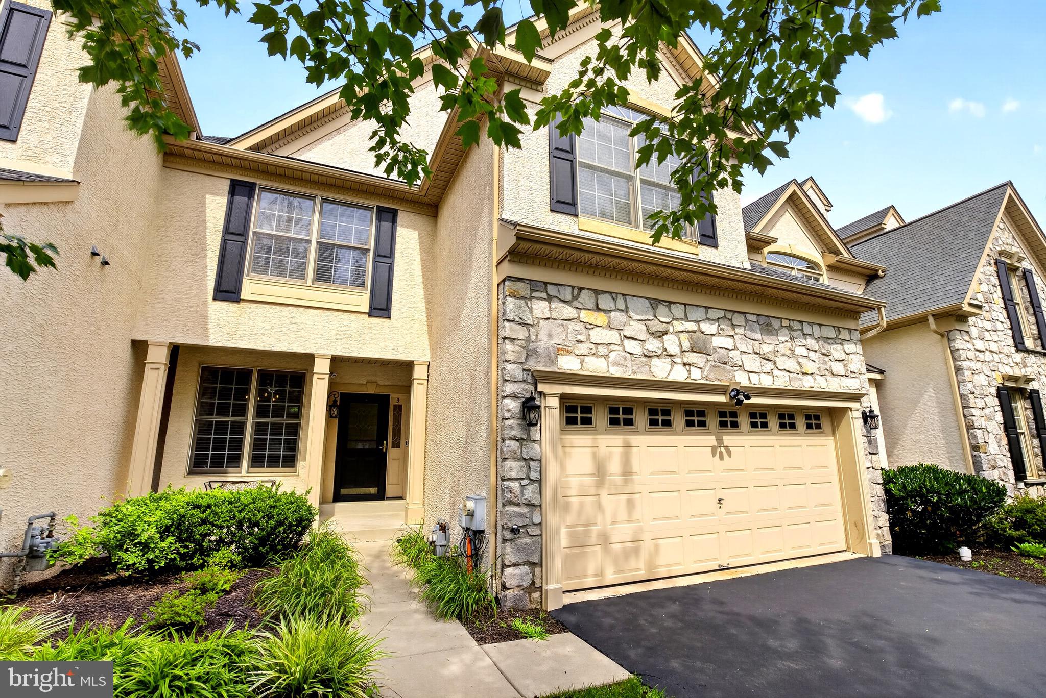 Welcome to 3 Penn Crossing, a beautifully maintained Luxury Carriage House in East Norriton's highly sought-after, low-turnover Reserve at Penn Crossing. Step inside to an open-concept first floor featuring a formal dining room that opens into a sitting room, sharing a double-sided fireplace with the adjoining two-story family room. Oversized, two-story windows and an atrium door fill the family room with natural light, with direct access to the deck and kitchen as well. The kitchen offers granite countertops and well-maintained maple cabinetry, with a breakfast nook overlooking the front porch, ideal for entertaining. The first floor is completed by an integrated two-car garage, a powder room, and a laundry area. Upstairs, an open loft space overlooks the family room below, ideal for a home office or sitting area. The primary bedroom offers oversized windows with ample natural light, vaulted ceilings, two walk-in closets, and an en-suite full bathroom. Down the hall, two additional generously sized bedrooms, along with a second full bathroom. The finished basement includes a second powder room, perfect for entertaining. Outside, a covered porch and a deck with a motorized awning offer space to unwind or entertain. Move-in ready, this home has been updated since its last sale with a new roof, new hardwood flooring on the main level and throughout the second floor, and new stair railing and balusters. Enjoy the neighborhood's walking trails and nearby shopping, with quick access to Routes 202, 276, 476, and 76 keeping daily life and commuting easy. Showings by appointment.