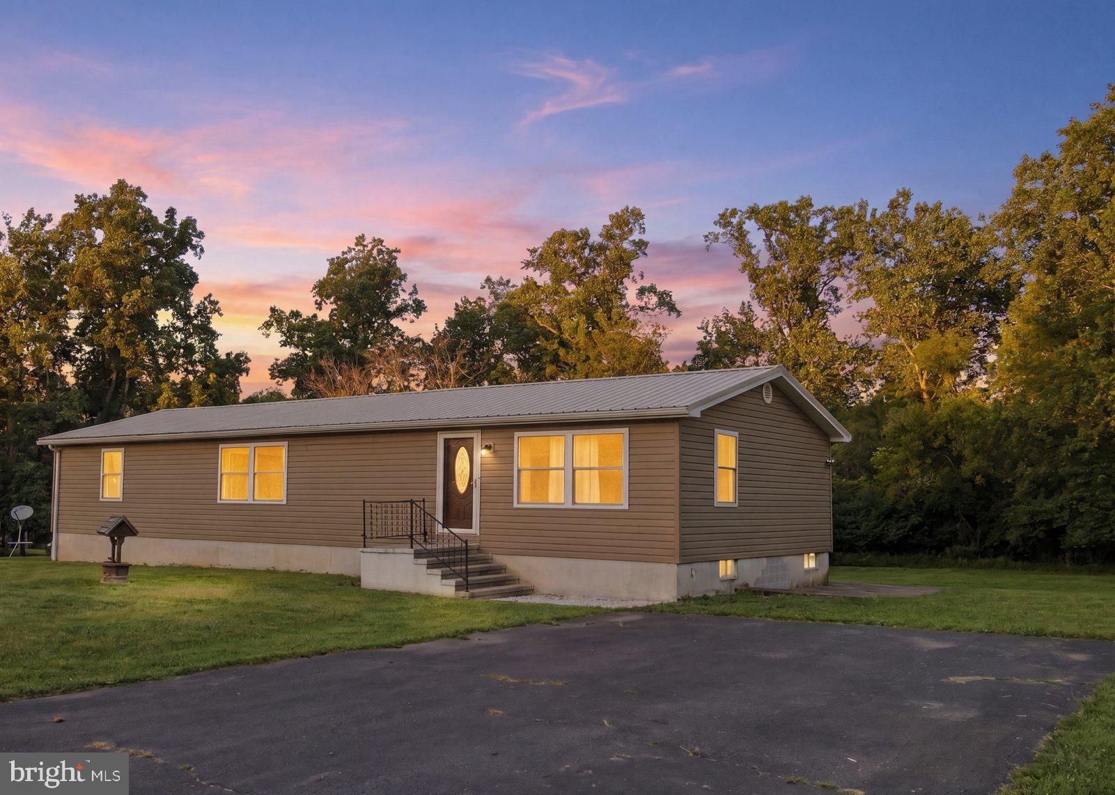 Nestled on over 2 Acres, this charming 1400+sqft  Ranch Style home offers comfortable one-level living with 3 Bedrooms and 2 Full Baths on Main Level plus a full unfinished lower level for plenty of extra room.  The home sits on a beautiful level, treed lot  with plenty of open space to enjoy outdoor activities, gardening, or future improvements.  With no HOA restrictions, you'll have the freedom to make the property your own.  There are hardwood floors in two of the bedrooms (main and the one with carpet) and the main bath has heated floors. Conveniently located with easy access to major commuter routes, this property combines peaceful country-style living with everyday accessibility.