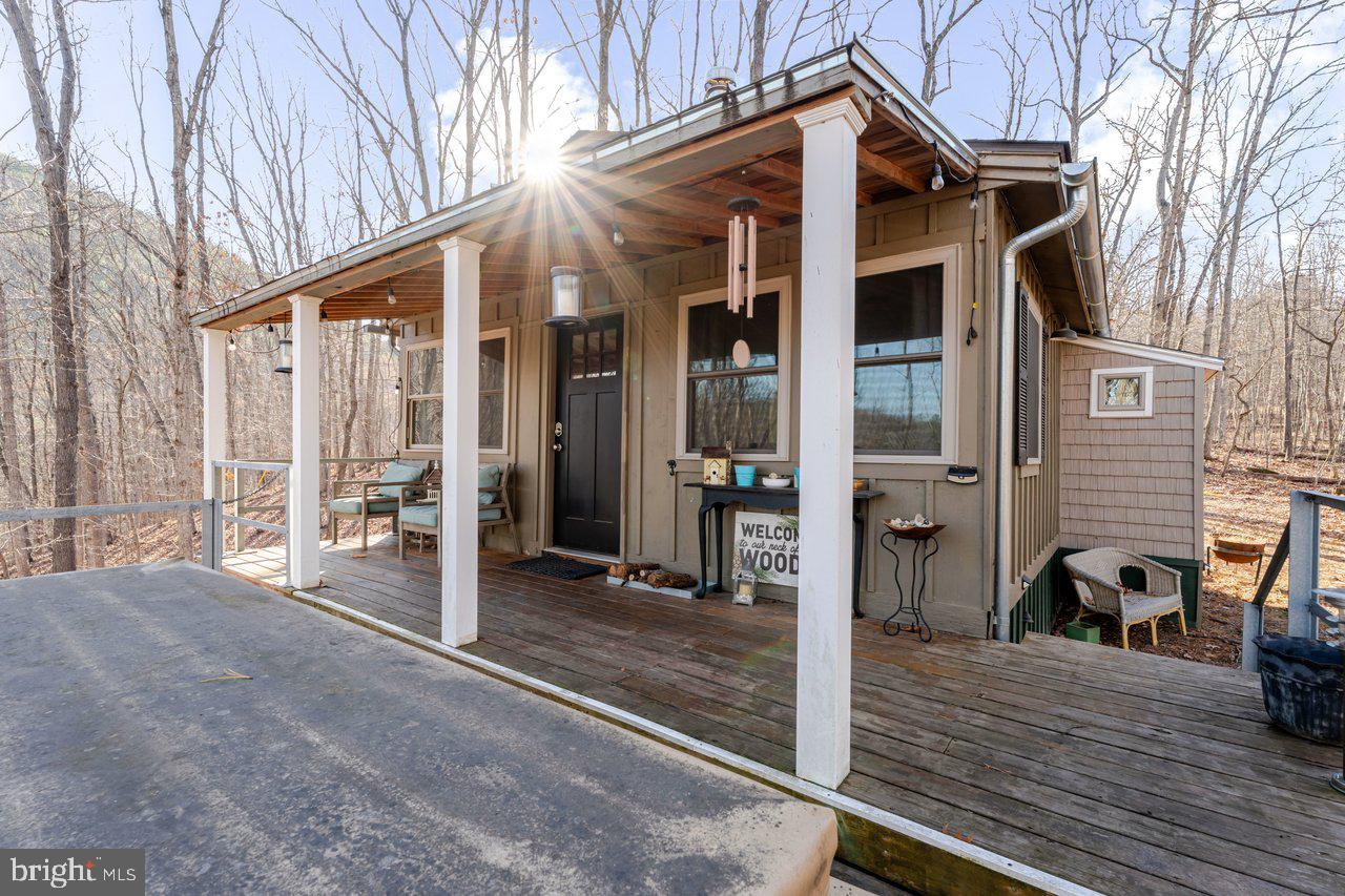 Total privacy meets cozy cabin comfort. Nestled on nearly two acres of mature timber near the George Washington National Forest and Shenandoah River, this 2-bedroom escape is designed for anyone looking to unwind. The secluded lot offers no traffic, no noise- just mountain views, valley vistas, and absolute quiet. The interior features gorgeous hardwood floors, a combination kitchen/living layout with a center island, and a classic wood stove for perfect cabin ambiance. Sold fully furnished and entirely move-in ready, the property shines outdoors with a massive expanded desk, with relaxing views, custom exterior lighting, and a dedicated fire pit area. Whether you want a low-maintenance basecamp for hiking or river trips, or a solitary weekend retreat, this hidden gem offers an escape that's getting harder and harder to find.