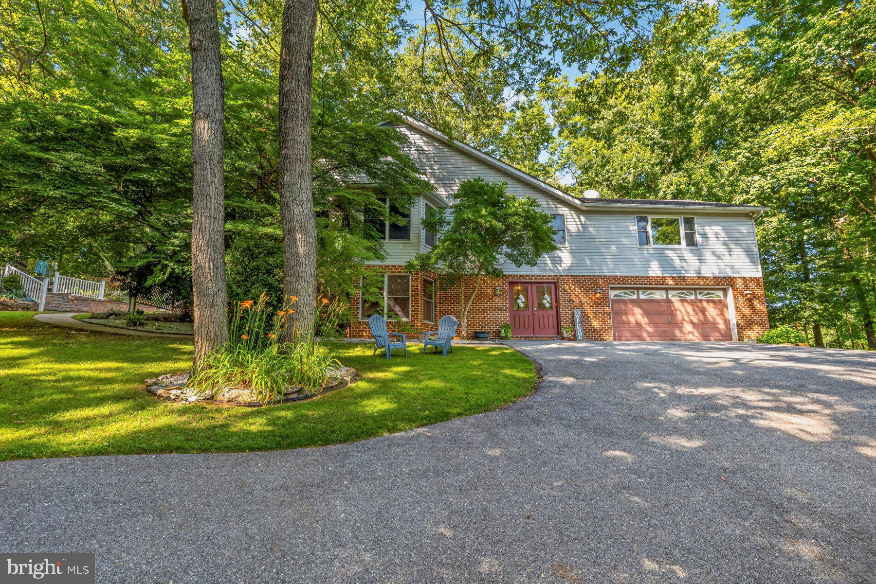 Welcome to this beautifully maintained home, perfectly nestled on a picturesque lot surrounded by mature trees that provide both privacy and a tranquil setting. From the moment you arrive, you'll appreciate the inviting curb appeal, spacious two-car driveway, and outdoor spaces designed for entertaining and relaxing.

Inside, abundant natural light fills the home, highlighting the gorgeous hardwood floors that extend throughout the entire main level. The thoughtfully designed floor plan offers three spacious bedrooms and two full bathrooms on the main level, creating comfortable one-level living, while the fully finished lower level adds a fourth bedroom and an additional full bathroom—ideal for guests, extended family, or a private home office.

The home features multiple oversized living and family rooms, providing endless flexibility for gathering, entertaining, or simply unwinding. Cozy up by the fireplace or enjoy the warmth of two wood stoves, including a lower-level wood stove equipped with an exhaust fan that helps circulate heat to the upper level for added comfort and efficiency.

Step outside to discover a backyard that's perfect for entertaining, whether hosting summer cookouts, playing with pets, or enjoying peaceful evenings under the trees. A separate stone patio at the front entrance creates another inviting outdoor space to relax with your morning coffee or gather with friends.

This home has been thoughtfully updated for its next owner, including a new roof (2019), hardwood flooring throughout the main level (2019), a UV light system for the well (2024), and a new water heater and pressure tank (2026). The kitchen features newer appliances, including a dishwasher, refrigerator, stove, and microwave (2025–2026), while the washer and dryer are approximately four years old. Recent cosmetic improvements include refinished lower-level full bathroom (2025), fresh paint throughout most of the upper level, the entire lower level, and all bedrooms (2025–2026), along with new luxury vinyl plank flooring throughout the lower level, excluding the storage closet and laundry room (2025).

As an added bonus, the home conveys with a pool table, ping pong table topper, dart board, second refrigerator, and standalone freezer, making it move-in ready for entertaining from day one.

Offering generous living space, quality updates, abundant natural light, and exceptional indoor and outdoor entertaining areas, this is a home you'll be proud to own for years to come.