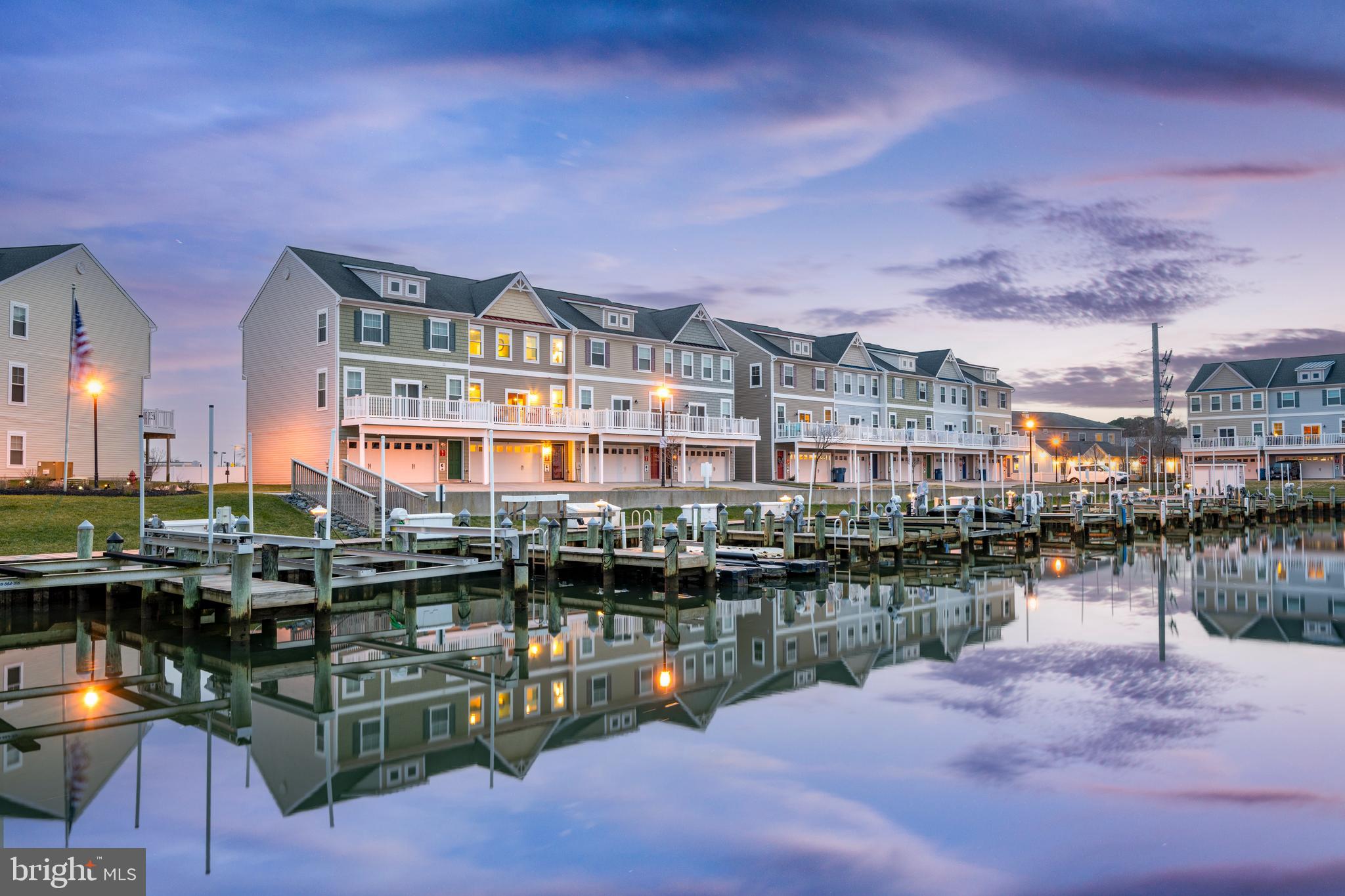 This 4-bedroom, 3.5-bathroom townhouse in Ocean City is truly a boater's dream come true!  With an attached 2-car garage and a deeded boat slip featuring a 10,000 lb lift, it offers the perfect setup for aqua sports enthusiasts and fishermen.  This unit's location is ideal, situated right across the marina, allowing you to dock your boat conveniently.  The first floor boasts a Captain's quarters with a full bath, providing a convenient space for guests or storing gear after a day on the water.  Head upstairs to the main living area, where an open kitchen/dining area awaits, complete with a large breakfast bar, stainless steel appliances, glass back-splash, and open to the spacious living room.  The deck off of the living room offers breathtaking views of downtown Ocean City, making it an ideal spot for enjoying happy hour or your morning coffee.  The property's proximity to various restaurants and bars, such as Hooper’s, Bad Monkey, Micky Fins, Pancho & Lefty’s, and Outback Steakhouse, means you won't need to use your car until you head back home.  The three bedrooms on the third floor, including the master with vaulted ceilings and an en-suite bathroom, provide a comfortable retreat after a night out.  The location is unbeatable, with direct access to the Rt. 50 bridge, eliminating the need for a long boat ride through the back bays of Ocean City.  You can easily walk to popular downtown Ocean City spots like Spain Wine Bar, M.R. Ducks, or The Angler for a night of entertainment.  Plus, the property offers the convenience of a short walk to Starbucks, Chic-fil-A, and the Outlets Ocean City for shopping.  Seaside Village's amenities, including an outdoor pool, marina, gazebo, picnic area, and community center, add to the overall appeal. Managed by Mann Properties, one of the best in the area, this Ocean City beach home is a must-see.  Schedule an in-person tour today to experience the incredible lifestyle this property has to offer!  (Included Boat slip valued at 65k)