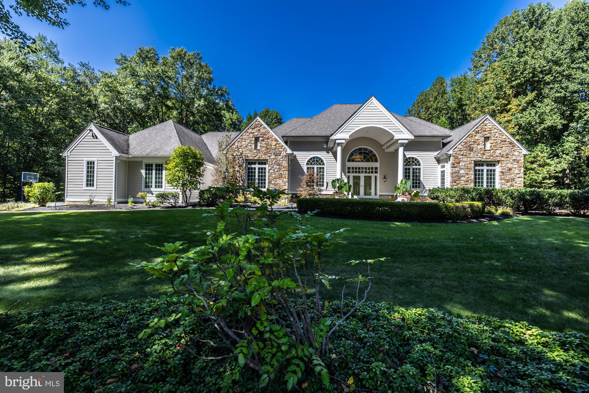Nestled on a picturesque 2-acre estate this custom-built masterpiece beckons those with a taste for upscale living. Boasting 8,257 square feet, the home features 6 bedrooms, 5 full bathrooms, 2 powder rooms and so much more. As you enter the sunlit grand salon you will be captivated with its gleaming oak and mahogany accented hardwood floors and new carpeting welcoming you to venture further. The soaring 16-foot ceiling and abundance of large windows bathe the space in natural light, providing breathtaking views of the rear yard, swimming pool, and gazebo creating a memorable first impression. 
As you continue through the cavernous main level, you will find an executive level home office, and a delightful formal dining area to entertain beloved guests. The kitchen, a culinary haven, is adorned with custom cabinets, high-end appliances, a center island with granite countertops, and breakfast bar. There is a convenient, beautifully appointed au-pair suite complete with a full bath just steps away. The adjoining family room was created as an expansive space designed for entertaining with a gas fireplace and provides entrance to the large rear deck seamlessly blending sophistication and comfort. Rounding out this area is a mudroom with custom-built wood lockers, coat closets and powder room, adding practicality to the luxurious living spaces. The main level reveals a primary suite that defines luxury living. This opulent retreat features a vaulted ceiling, gas fireplace and new plush carpets, creating a cozy ambiance. A spacious walk-in closet provides ample storage, while the sunlit primary bath offers a serene escape with a sunken tub, stall shower, and 2 single bowl vanities. Adjacent to the primary bath is a dressing room of grand proportions, featuring a center island and a generously sized lighted vanity mirror. The final bedroom on this level is a junior suite with new carpets, large windows, walk-in closet and en-suite bath.  
The lower level is an entertainer's dream, featuring three bedrooms, each thoughtfully designed for comfort and style. One bedroom boasts an en-suite full bath, while the other two share a Jack and Jill bath. An exercise room caters to the fitness enthusiast. Additionally, there are two laundry rooms, one on each level, ensuring convenience for the entire family. A full kitchen further enhances the entertaining possibilities, making this executive residence a true masterpiece in upscale living. This space can also be ideal for use as an in-law suite or for extended visits with family and friends The lower level also offers three other large flex rooms, providing versatility for various purposes, whether it be a home office, media room, or playroom. There’s even a gift-wrapping walk-in closet to make the holidays less strenuous.  Abundant storage space, along with a 4-car garage and a cavernous attic with high ceilings, adds to the home's functionality.  Step outside through the glass doors and discover an outdoor oasis. The large rear yard is a private haven, providing a serene backdrop for relaxation or lively gatherings. A spacious patio area, adorned with a heated swimming pool and hot tub, sets the stage for fun-filled summer parties. Whether it's a refreshing dip in the pool, lounging in the gazebo's shade, or hosting al fresco dinners under the stars, this outdoor space is designed for upscale entertaining and leisure. Situated in East Bradford Township in the esteemed West Chester Area School District, this home promises an unparalleled lifestyle. It's not just a house; it's a warm, welcoming family home designed for both luxury living and entertaining. Every detail, from the grand entrance to the exquisite living spaces and the inviting outdoor haven, invites you to experience a life of comfort and refinement. A few more key improvements have been made. Schedule a viewing to immerse yourself in the extraordinary.