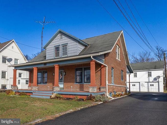 Charming brick home with an independent apartment above the detached garage. This Cape Cod welcomes you with an inviting front porch, hardwood floors throughout the main level, living room, dining room with a built-in cabinet, and a remodeled kitchen featuring Carrera marble counters and tile backsplash and 'Cafe' line stainless appliances. One bedroom and a full bath complete the first level.  The second floor offers hardwood flooring,  two more bedrooms with generous closet space, attic access, and a second full bath with Carrera marble floors and walls. The two-car detached garage comes with a comfortable apartment above featuring laundry,  kitchen, living/dining combo, 1 bedroom with closet and door to deck, 1 bath, and the walk-up attic could be finished for additional living space.  Other highlights include an unfinished basement in the main house,  a rear porch, and shed. This property has a cistern and public sewer.