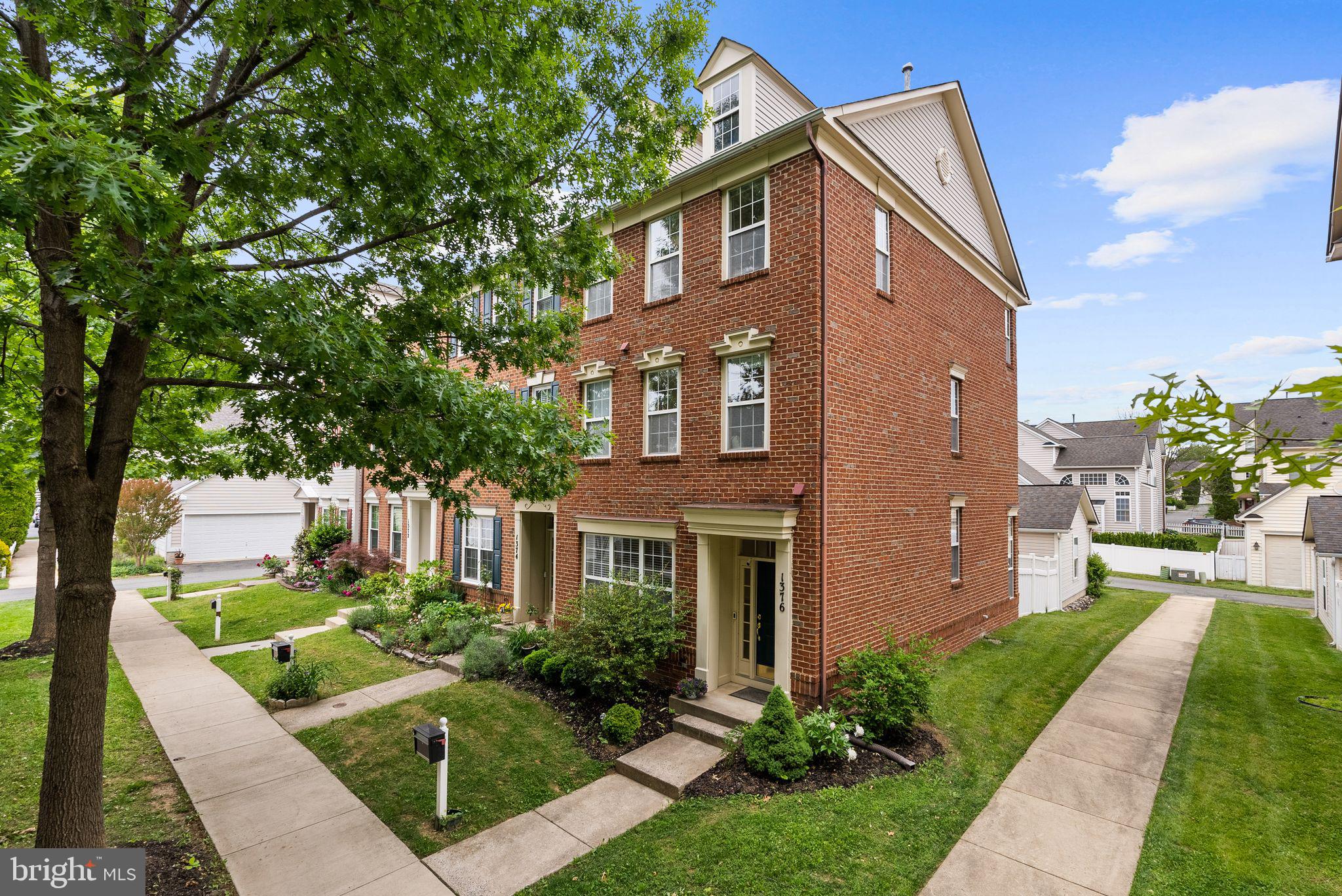**multiple offers received; last call!** Rarely does a home in the Lakelands offer this combination of design, finish, and setting. Welcome to 1376 Main Mews, a meticulously upgraded Miller & Smith Georgetown end-unit townhome overlooking the Butterfly Commons and set peacefully away from main roads.
Step inside and the difference is immediate. Soaring 10-foot ceilings on the main level create a sense of volume and light that sets the Georgetown model apart from anything else in this price range. The open-concept living and dining area flows into a fully remodeled luxury kitchen (2025) featuring premium cabinetry, designer finishes, and high-end appliances, a true centerpiece of the home. Hardwood floors grace the main level and staircase, while the upper levels feature a high-grade, light-toned laminate selected for both beauty and durability. The main level doubles as an entertainment destination with a ceiling-mounted projector and remote-controlled 120-inch motorized drop-down screen, both conveying with the home, perfect for movie nights, game days, or an immersive cinematic evening experience unlike anything you’ll find in a traditional living room.
On the 2nd level, the primary suite offers a private retreat with two separate generous closets and a completely redesigned en-suite bathroom (2025) with modern fixtures and elevated finishes. A dedicated home office, thoughtfully converted from the original den, features modern built-in shelving and a clean, contemporary design, all conveying with the home. The 3rd level features the Georgetown model’s signature vaulted spaces with 10+ foot ceilings which add architectural interest. Additional 2 bedrooms are spacious and bright, sharing an updated Jack & Jill bathroom with two vanities, and offer large closet space. Flexible living space with signature vaulted ceilings can easily serve as a recreation room, media lounge, or home gym. Fresh paint throughout and thoughtful updates at every turn mean this home is truly move-in ready, no projects, no compromises.
Outside, a private stone patio is tucked between the home and the two-car garage, creating an enclosed outdoor living space ideal for grilling, morning coffee, or quiet evenings. As an end unit with brick on the front and side, the home offers enhanced privacy, natural light from multiple exposures, and timeless curb appeal. The Butterfly Commons, a native meadow sanctuary created in partnership with the City of Gaithersburg and the Chesapeake Bay Trust, sits directly in front, providing a serene, green backdrop with walking paths and gardens. It’s a rare amenity that offers permanent open-space protection and a connection to nature steps from your front door.
Location within the Lakelands is equally compelling: walking distance to Lakelands Park Middle School, community stadiums (soccer and two baseball fields), lakes, and the full suite of Kentlands/Lakelands amenities including pools, tennis courts, trails, and the vibrant town center with Whole Foods, dining, and shopping. This is not just a townhome — it’s one of the most thoughtfully finished Georgetown models in Lakelands, in one of its most desirable locations. Homes like this don’t wait.