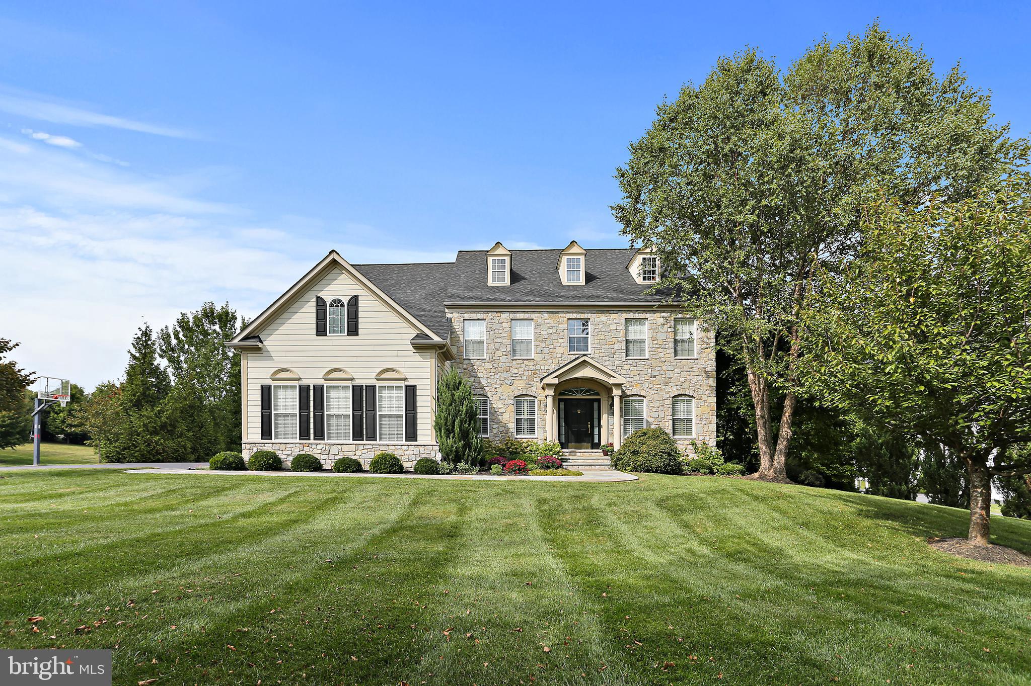 This exceptional home blends timeless elegance with thoughtful modern updates sited on a prime lot offering spectacular views to your own private pasture. The original owners have meticulously maintained and upgraded the entire home, including the kitchen and all bathrooms. The main level boasts a beautifully remodeled kitchen featuring luxurious quartz countertops, updated cabinetry and stylish fixtures. A grand staircase with refinished treads and updated railings serves as a stunning centerpiece, while premium Barcelona White Oak engineered hardwood flooring enhances the space. The upper-level primary suite offers a spa-like retreat with a remodeled bath, heated tile flooring, a soaking tub, and custom built-ins in the walk-in closet. The fully finished basement was transformed from a walk-up to a walk-out in 2015 and includes a custom solid wood entertainment center (conveys), wired surround sound, a guest room with en-suite, and a complete basement kitchen—ideal for guests or extended living space.
Outside, the professionally designed landscape offers a private oasis with an expansive covered deck constructed of high-end, heat-treated American ash, flagstone patio, and a maintained meadow featuring 80+ strategically planted trees for privacy. This unique property includes a 4.1-acre environmental land preserve, ensuring a peaceful pastoral view. The home’s exterior is clad in genuine 5-inch-thick full-depth natural stone, not a veneer, adding lasting beauty and durability. A spacious, finished, three-car garage features an epoxy-coated floor for a polished finish. 
Owners have invested in luxurious upgrades and special features! Extra upgrades include a whole-home 20kW Generac generator and even a new roof (2024). With high-end finishes, smart home security, and extensive enhancements throughout, this home is a rare find that perfectly balances comfort, style, and functionality.