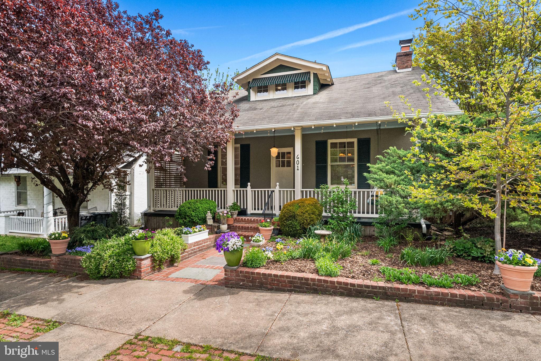 OPEN THIS WEEKEND:  Saturday, May 16th  12-2 pm  Sunday, May 17th 2-4 pm
• Welcome home to 601 N View Terrace in exclusive Rosemont — a stunning 6-bedroom, 3.5-bath Sears Craftsman bungalow on a spacious corner lot with beautiful curb appeal and professional landscaping.
• FRONT PORCH: Large, inviting, and picture-perfect with a hanging swing — ideal for morning coffee or relaxing outdoors.
• ENTRYWAY & LIVING SPACE: Freshly painted interior with gleaming hardwood floors. Living room features a wood-burning fireplace with a classic mantle and a striking light fixture that reflects the home’s timeless charm.
• LIBRARY: To the right of the entry, a full wall of built-ins and chandelier lighting creates a warm, functional space for reading or working from home.
• FORMAL DINING ROOM: Spacious with a bay window, window seat, original/vintage lighting, and abundant natural light — perfect for entertaining.
• KITCHEN: Recently updated with stained glass windows, stainless steel appliances, including a brand-new dishwasher, a Viking 5-burner gas range with matching vent hood, and new quartz countertops. The breakfast room is filled with natural light and overlooks the backyard oasis.
• PRIMARY SUITE: Located on the main level, featuring a spacious bedroom with abundant light, an attached sitting/dressing area, and a newly renovated en suite bath with tiled shower with dual heads, a vintage vanity, and new fixtures and lighting.
• POWDER ROOM: Unique touches include original New Yorker covers adorning the walls.
• UPPER LEVEL: Three well-appointed bedrooms with walk-in closets, freshly painted walls, and hardwood flooring. The updated hall bath, with wainscotting, a tub/shower combo, and a vanity, completes this level.
• LOWER LEVEL: Feels like an additional home — includes two bedrooms with ample natural light and closets, a rec room with walk-out access to the patio, and a full updated bathroom with a shower. A large linen closet is also on this level.
• BACKYARD OASIS: Professionally landscaped with multiple living spaces — walk-out patio from lower level, Trex deck off breakfast room, and paver sitting area near detached studio. Perfect for entertaining, relaxing, or outdoor activities.
• DETACHED STUDIO: Accessible from side street or backyard — ideal for an office, home gym, workshop, or creative space.
• LOCATION: Moments to charming Del Ray shops and cafes, and to Historic Old Town and its waterfront shops and restaurants. Close to 395 and the Braddock St METRO, it's a breeze of a commute to Washington DC, National Landing, and more.
• This home offers an incredible blend of character, modern updates, and flexible living spaces — WELCOME HOME! Love where you live!