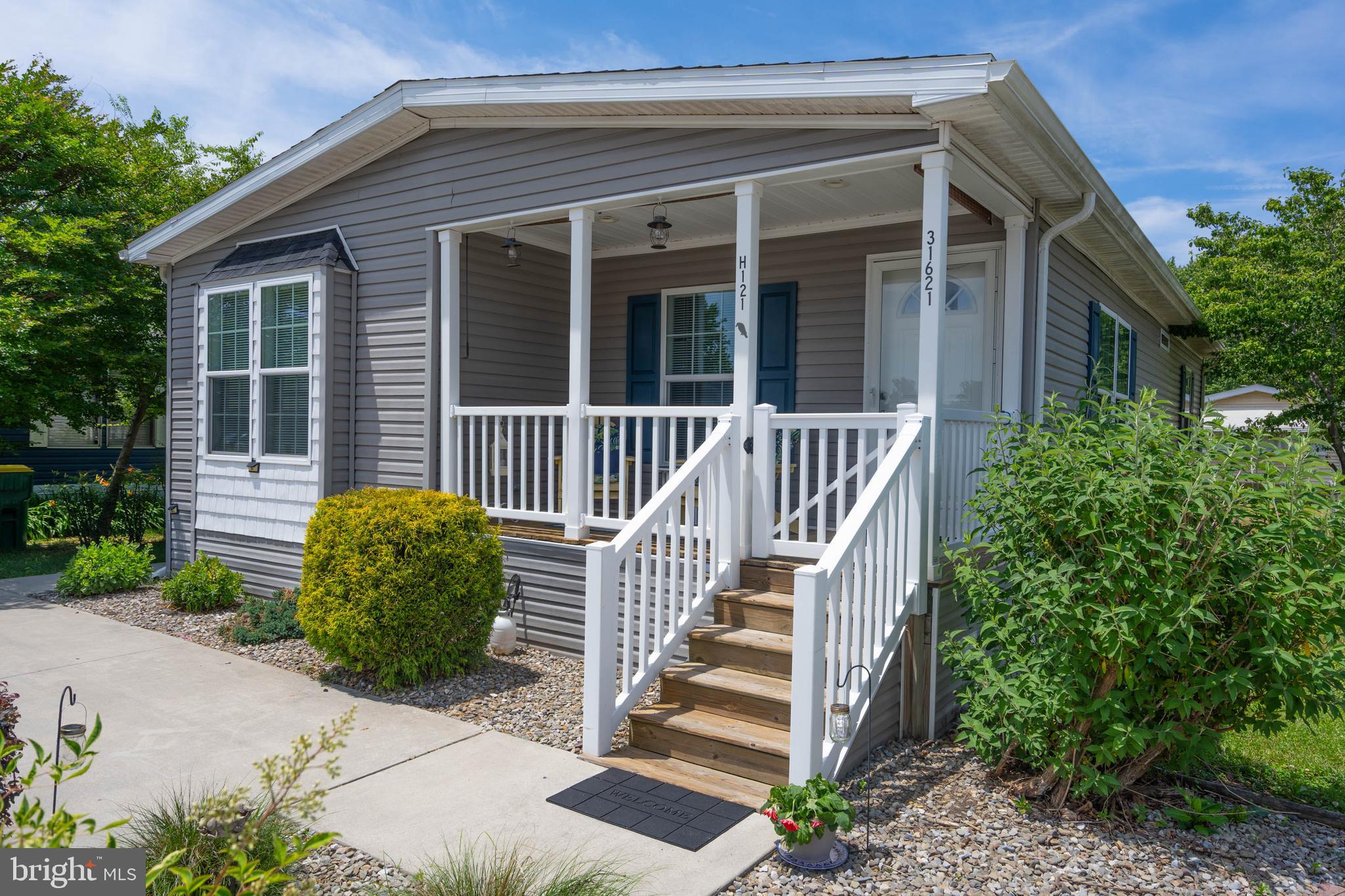 Welcome to 31621 Dogwood Court in the year-round community of Whispering Pines! Built in 2018 and tucked away on a quiet court just off Route 1, this well-maintained 3-bedroom, 2-bath home offers the perfect combination of convenience and privacy. Lightly lived in and showing pride of ownership throughout, the home feels fresh and move-in ready. A covered front porch with a latching gate creates a welcoming outdoor space to relax and enjoy the neighborhood. Inside, you'll find a bright and inviting interior featuring a thoughtfully designed kitchen and living area that maximizes both comfort and functionality. The open-concept layout creates an easy flow for everyday living and entertaining, while the split-bedroom floor plan provides privacy for the primary suite. Offered partially furnished, this home makes moving in a breeze.  Residents of Whispering Pines enjoy access to a community pool and the benefits of a year-round community, all while being conveniently located just off Route 1. You'll be minutes from Downtown Lewes, Rehoboth Beach, shopping, dining, and everyday conveniences, making this an ideal primary residence or coastal retreat. Current lot rent is $786.03 per month. Move-in ready and rarely used, this home is ready for its next owner to enjoy.