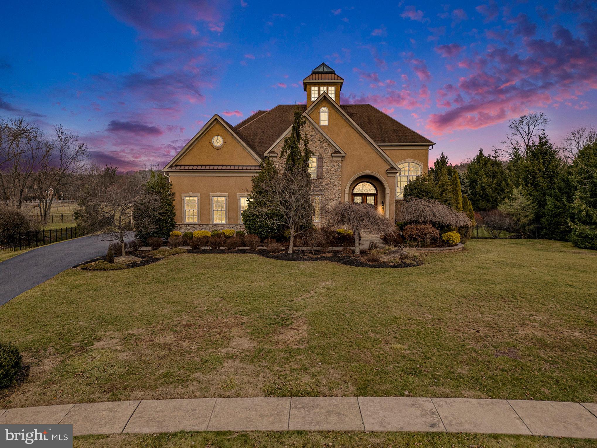 Privacy, luxury & leisure time are paramount on this stunning corner lot property in the estate neighborhood of Heritage Hunt. At over 6,000 square feet, the home offers four bedrooms (all with ensuites), an elevator and plenty of bonus space. Inside the front doors, you’ll find a grand 2-story foyer, miles of custom millwork, modern fixtures and large windows that fill the home with natural light. The beautiful formal dining room off the foyer wows with hardwood floors, crown molding and a bay window. 
No expense was spared in the gourmet kitchen, which features granite countertops, a Wolf range (+a bonus wall oven), a custom Sub-Zero fridge, a walk-in pantry, an espresso bar, a breakfast nook and a massive island with storage & bar-top seating. And just steps away, you can dine alfresco on the elevated back deck. The kitchen is open to the huge great room, complete with soaring ceilings, a dramatic floor-to-ceiling stone fireplace and backyard farm views. There’s even more room to entertain in the beautiful sunroom, which opens to the atrium on one side and gives you direct access to the covered paver patio on the other. The elevator at the center of the floorplan looks like a piece of art. You can climb the light-filled atrium staircase or take the elevator to the upper level, where you’ll find all the bedrooms. The corner primary suite includes tray ceilings and a large sitting area. The ensuite boasts two walk-in closets (with custom storage), dual sinks, a soaking tub and a frameless glass shower. The three spacious guest rooms all include access to an ensuite (one private, one Jack & Jill). Still need more space? Head down to the lower level, where everyone has room to spread out. Your guests can gather around the full bar, or you can host game night in front of the second stone fireplace. The rest of the lower level offers a full bathroom and two flex spaces that could be used as a bedroom, home office, playroom, gym or homeschool headquarters.  The basement also walks out to that amazing fenced-in backyard oasis! You’ll spend all summer lounging around or swimming in the concrete pool and listening to that soothing waterfall. You can also enjoy your morning coffee in the charming gazebo.  Don’t forget about the full laundry/mudroom at the entrance of the attached side-entry garage. Another BONUS: This unique property offers an additional detached 3-car garage & workshop. Every estate within Heritage Hunt sits on a large lot, and 4039 Steeplechase Dr. enjoys stunning horse farm backyard views, too. You’ll be five mins from all the quaint shops in the village of Skippack, with Providence Town shopping center just 10 minutes in the other direction. Twenty minutes to King of Prussia & 45 minutes to Philadelphia; zoned to top-ranked Perkiomen Valley schools! You have to see this special property in person to appreciate!