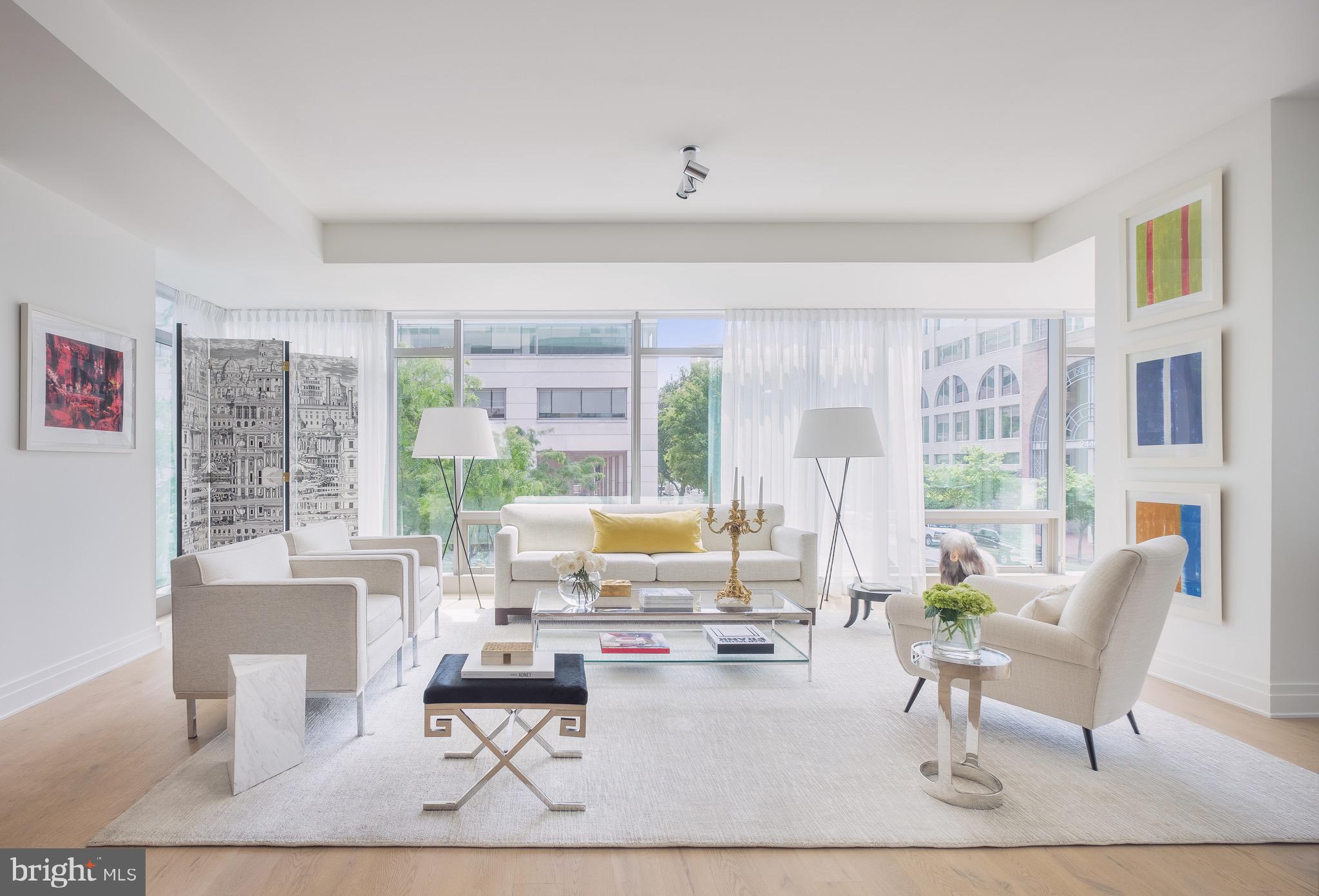 One-of-kind unit, with TWO BEDROOMS + DEN, this is one of the city’s most desirable and discerning addresses for fine urban living. Unit 203 profiled in Southern Living Magazine is rare offering: an airy, expansive 2,200+ square foot residence where form meets function in a harmonious blend of clean modernism and timeless materials. The home delivers a masterful level of design intention, featuring bespoke upgrades that speak to both architectural sophistication and everyday comfort.

As you enter, you're greeted into a gracious foyer and then you step into the breathtaking, light-filled interior. Floor-to-ceiling windows along multiple exposures floods the open-concept living spaces with natural light, offering uninterrupted views of mature foliage and an elegant transition to the private balcony — a serene perch, the ideal place to enjoy morning coffee.

The spatial layout is fluid and intuitive featuring wide plank white oak flooring and bespoke lighting -- anchored by a gourmet kitchen that serves as both a culinary workspace and a visual focal point. Outfitted with sleek cabinetry including a custom-crafted pantry, premium stainless steel appliances (Bosch and Thermador), natural countertops and a waterfall island with seating for three or more, the kitchen is open to the living and dining zones, each defined by expansive sight lines. The foyer area rounds out with a walk-in coat closet and a chic and whimsical wallpapered powder room for guests.

The spacious primary suite is a serene, private retreat conceived for ease and indulgence -- easily accommodating a king sized bed and multiple furniture layouts. The expansive window features custom tailored black-out draperies. The white and crisp ensuite bath delivers a double vanity, finely crafted porcelain tile work, an oversized shower with European fittings, and a secluded water closet. Down the hall, the light-filled second bedroom adapts easily to varying needs, whether as a guest room, library or studio. The en suite full bath, thoughtfully designed with a tub/shower configuration, delivers comfort for both residents and guests.

Down the hall is the custom-designed den -- a jewel box featuring an artisan glass partition and door and a signature chandelier -- an ideal space for cozy movie nights in.

This singular residence is further enhanced by two dedicated parking spaces and in-unit, full-sized laundry with energy efficient front loading machines.

Residents benefit from an extensive suite of outstanding building amenities including The Cove a stylish community room with a wet bar and meeting rooms, a state of the art fitness center with access to a trainer, yoga studio, 24-7 desk attendant, concierge services, and a beautifully landscaped rooftop terrace offering panoramic views across the city skyline.

Located just steps from the vibrant heart of the city — with Georgetown, Rock Creek Park, Michelin-starred dining, boutique shopping, and Metro access all within walking distance — 2501 M is not simply a residence, but a refined living destination in one of Washington’s most coveted boutique condo buildings.

Welcome Home!