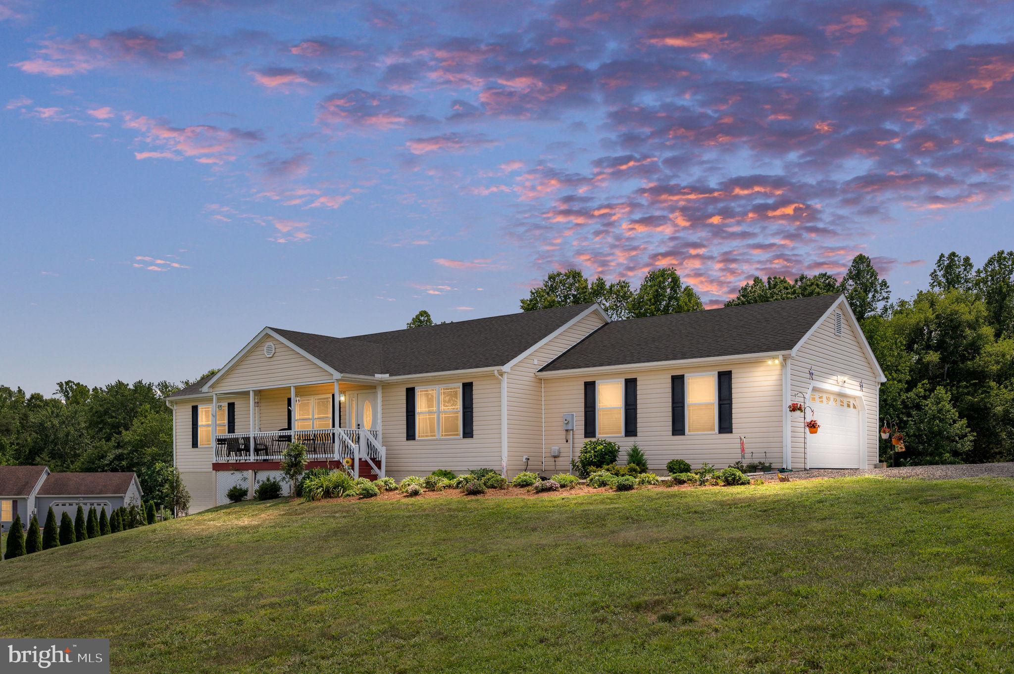 Imagine ending each day by turning off the busy road and winding into your own peaceful retreat. Although you're only about a mile from town, you'll feel miles away as you arrive home to nearly 3 private acres nestled at the end of a quiet cul-de-sac. With mature woods, open lawn, and no HOA, this is the perfect blend of country living and everyday convenience.

Spend your mornings sipping coffee in the sunroom as you watch wildlife wander through your backyard woods. Tend to your raised-bed gardens, gather fresh vegetables for dinner, or simply enjoy the peace and quiet that surrounds you. There's plenty of room for hobbies, outdoor equipment, and weekend projects with a large storage shed featuring a roll-up door and an expansive lower-level workshop complete with a concrete floor, French door entrance, and massive encapsulated crawl space for exceptional storage.

Inside, vaulted ceilings create an open, airy atmosphere while beautiful hardwood floors flow throughout the main living areas. The kitchen is designed for gathering with granite countertops, a breakfast bar, and an easy flow into the living spaces—perfect for entertaining family and friends.

When the day is done, retreat to the spacious primary suite featuring a large walk-in closet and a private ensuite bath designed for comfort and relaxation.

An oversized side-load garage and abundant off-street parking provide room for vehicles, boats, trailers, and guests alike.

If you've been searching for a property that offers the serenity of country living without sacrificing the convenience of shopping, dining, schools, and everyday amenities just minutes away, this is the lifestyle you've been waiting for.