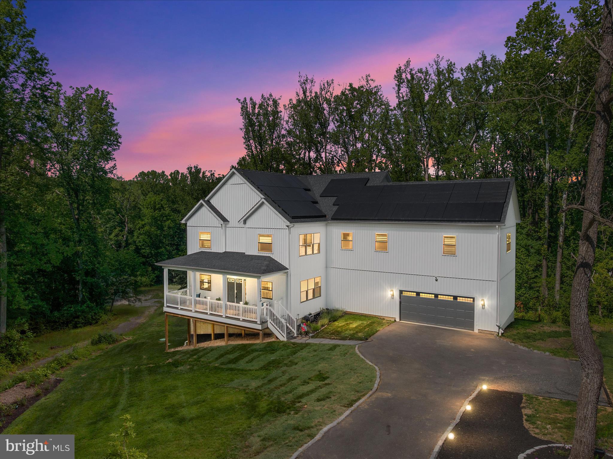 Welcome to 16608 Sylvan Drive, a stunning custom-built home by Legend Builders situated on a private 2-acre homesite in Bowie. Only two years young, this exceptional residence combines timeless craftsmanship, luxury finishes, and modern energy efficiency throughout. From the inviting front porch and grand foyer, you'll immediately appreciate the attention to detail, including 10-foot ceilings, oversized moldings and trim, solid wood interior doors with dark bronze farmhouse-style hardware, and upgraded designer lighting throughout. The thoughtfully designed floor plan offers over-the-top functionality with 4 spacious bedrooms, a meditation room which can be used as a private office or gym, an upper-level loft, and a main-level in-law suite complete with its own full bath. The heart of the home is the impressive gourmet kitchen featuring slow close cabnetry, cambria quartz countertops, an oversized center island, premium Monogram appliances, a walk-in pantry, and seamless flow into the dramatic two-story family room. Soaring 20-foot ceilings, a marble fireplace surrounding a linear fireplace, and abundant natural light create the perfect space for everyday living and entertaining. Upstairs, the luxurious primary suite offers dual walk-in closets and a spa-inspired bath that includes a double vanity with cambria quartz countertops, soft-close cabinetry, a soaking tub, and a separate oversized rain shower. An upper-level laundry room with built-in cabinetry and GE appliances adds everyday convenience. Step outside to the rear patio and enjoy peaceful views of the tree-lined backyard, creating the perfect setting for morning coffee, outdoor dining, entertaining guests, or simply relaxing while taking in the privacy and natural beauty of the surrounding landscape. The expansive walkout basement with a full bath rough-in boasts approximately 1700 sqaure feet of endless possibilities. Built for comfort and efficiency, the home features fully owned solar panel system offsetting energy costs up to 100% in the summer months while providing long-term energy, efficiency, and sustainability.  Other Exceptional Features Include: Dual-zone Carrier HVAC for year-round comfort and efficiency, two water heaters for uninterrupted hot water, and a comprehensive security package featuring a security system and video doorbell camera for enhanced safety and peace of mind. These valuable upgrades contribute to the home's comfort, convenience, and modern lifestyle appeal. Perfectly positioned for commuters, this exceptional property offers convenient access to Washington, D.C., Northern Virginia, Baltimore, and Annapolis, making it ideal for those seeking both privacy and connectivity. Enjoy being just minutes from excellent shopping, dining, entertainment, parks, and major commuter routes while coming home to the peace and tranquility of your own private 2-acre retreat. Offering the perfect blend of luxury, privacy, modern efficiency, and an unbeatable location, this exceptional home is a rare opportunity in one of Bowie's most desirable settings.