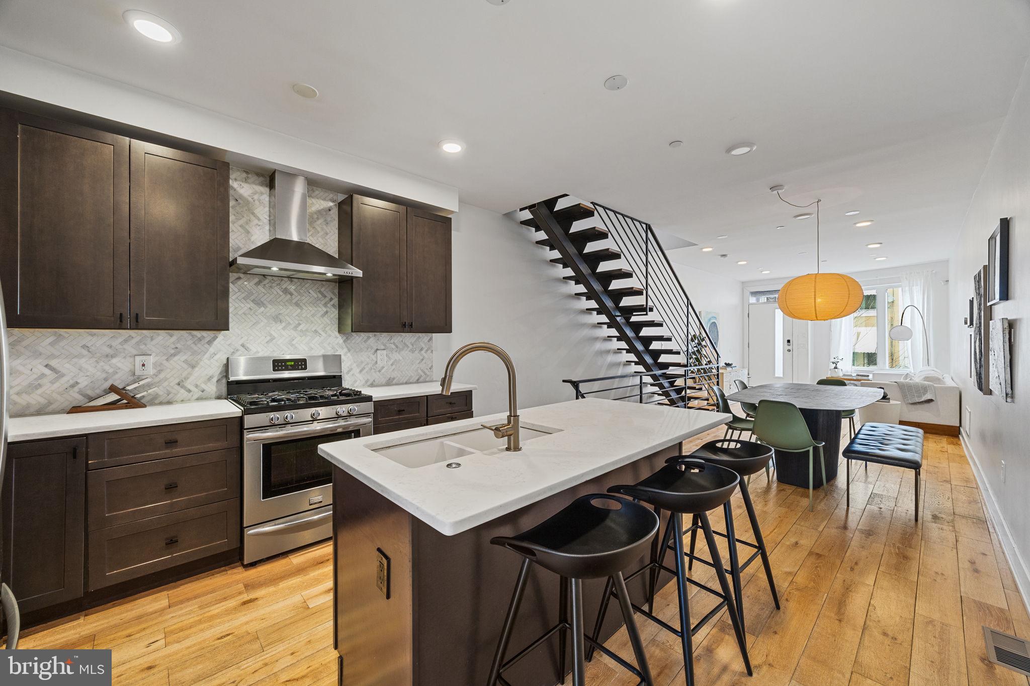 Don’t purchase a home in Philadelphia without touring this one! 1423 N. 27th Street is located across the street from Brewerytown Garden, the vibrant, neighborhood-run nonprofit providing space for 75 Brewerytown households to grow their own produce. Also, a half block away you’ll find Athletic Square, the 5 acre green space, surrounded by mature London Planetrees, planted by the City 100 years ago years ago. If they look familiar, you’ll find this same species of tree along Kelly Drive at the Philadelphia Museum of Art. You'll also love the coffee shop at the bottom of the block, Together Skateboarding and Cafe. Upon entry, you’ll appreciate the sophisticated interior. Spacious main level with a distinct living and dining areas and upgraded kitchen. Half bathroom at the back of the main level for convenience. Rear patio surrounded by red brick walls creates chic, urban oasis perfect for dining and entertaining. From the living room, ascend floating stairs to the second level where two amply apportioned bedrooms are split by laundry room and a full bath with double vanity. You’ll be impressed by the size of each bedroom as well as the long hallway separating each which affords additional privacy for both. On the third level you’ll find a full wet bar and primary bedroom suite. The eastern exposure of the home converts the primary bedroom into a virtual light machine after sunrise with long beams of sunlight entering an hour or so after first light. Walk-in closet, double vanity, walk-in shower, and soaking tub highlight the primary bath. Of course, the roof deck presents some of the best Center City views in the neighborhood. The night views are best. A perfect spot for a glass of wine, evening cocktail, or even morning coffee. Don’t miss the fully-finished, day-lighted basement with a front den and fourth bedroom with full bath. It’s a the most versatile level of the home. Perfect for fitness, playroom, media room, work from home, guest suite, or roommates. Modern but not cold. Charming and sophisticated. With approximately two years remaining on the property tax abatement, this row home presents remarkable value at this price. Visit an open house or schedule your showing today!