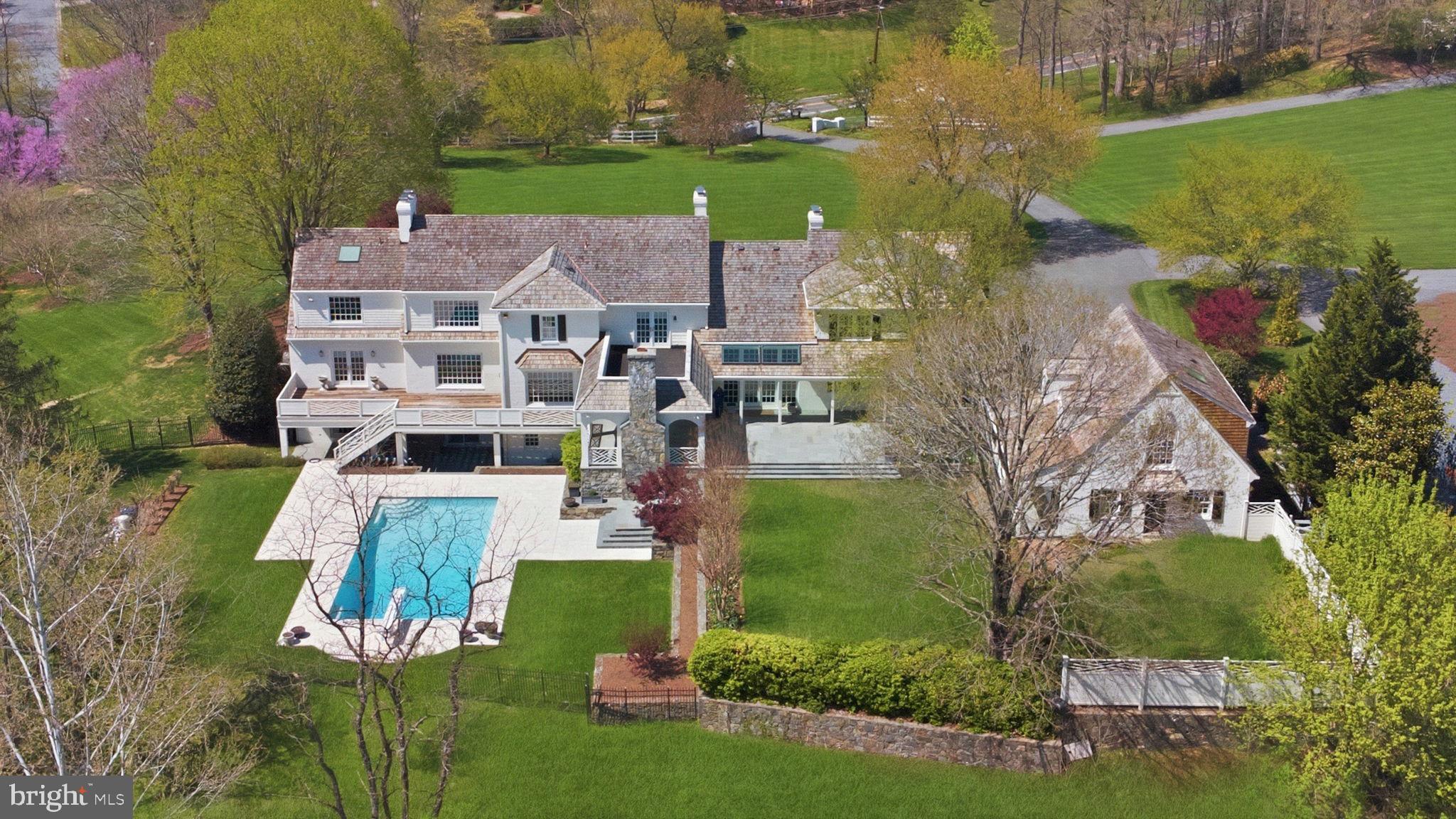 Welcome to 11101 Piney Meetinghouse Road — a timeless Colonial cottage estate where warmth, craftsmanship, and natural beauty come together in perfect harmony.

Set on a private two-acre homesite in a charming Potomac neighborhood and surrounded by a breathtaking 26-acre wooded natural park with a gently flowing stream, this exceptional residence offers a rare sense of peace and seclusion. Built by renowned Foulger Pratt with thoughtful designs by Rixey, the home is being offered for the very first time—lovingly maintained, expanded, and beautifully updated by its original owners.

Inside, high ceilings and elegant proportions create a gracious yet inviting atmosphere. A thoughtful blend of formal and informal spaces includes a refined living room with fireplace and millwork, a richly appointed cherry-paneled library, an inviting family room, and a sun-filled music room. The lofted dining area, wrapped in walls of windows and French doors, opens seamlessly to patios and decks—perfect for indoor-outdoor living and entertaining.

The chef’s kitchen has been tastefully updated with high-end finishes, complemented by refreshed bathrooms throughout the home, which features six full baths and two half baths. A whole-home generator and dual laundry areas provide comfort and convenience for everyday living. Notably, the property is served by public water and sewer with natural gas—an uncommon and highly desirable combination for a two-acre lot in Potomac.

The primary suite is a true retreat, offering lofted ceilings, a fireplace, dual dressing rooms, and a stunning, private study addition. This expansive, secluded space is warm and inviting, with beautiful wood paneling, wood floors, skylight, and tranquil exterior views—ideal as a private office, sitting room, or lounge, complete with a large-screen entertainment center and wet bar.

Designed with flexibility in mind, the home’s one-of-a-kind layout is ideal for growing families and multi-generational living. The walkout lower level has high ceilings and includes two additional bedrooms, a spacious recreation room, and a large fitness area with  a wall of windows—perfect for a golf simulator, dance studio, or home gym. A charming carriage house connected to the main home by a covered walkway adds even more versatility, featuring its own bedroom, living area, and kitchenette.

Outdoors, the property is truly extraordinary. Gorgeous natural dry-laid stone retaining walls, patios, and stairs blend seamlessly into the landscape, creating a setting that feels both curated and organic. A newer pool is complemented by a picturesque gazebo overlooking the water, enhanced by beautiful lighting and fountain features. A covered flagstone patio, outdoor fireplace, overhead heaters, and integrated AV make this an ideal space for year-round enjoyment. The English garden blooms across three seasons, while the deer fenced yard and irrigation system ensure beauty and ease of maintenance.

Extensively refreshed and move-in ready, recent updates include a NEW cedar shake roof (2025), freshly painted interiors, refinished hardwood floors, new luxury carpeting, updated and inspected electrical systems, NEW hot water heaters (2026), a replaced main water line (2025), and a new fire and security system (2025).

With two garages for 4 cars, generous driveway parking, and scenic views from nearly every room, this is a rare opportunity to own a gracious and lasting Potomac estate—where every detail reflects care, quality, and enduring elegance.

Note: Interior photos were taken prior to sellers move. Home is vacant, move-in-ready, and easy to show by appointment.