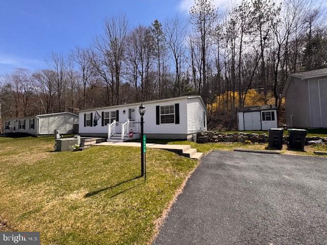NOTHING TO DO BUT MOVE INTO THIS NEWLY RENOVATED 3-BR, 2-BA 2000 Fleetwood (1,056 sq. ft) ranch home located in the (55+ and older) community of Blue Mountain Village. You'll love the open floor plan allowing you to move freely throughout the home. RECENTLY RENOVATED! NEW Roof, NEW Central Air, NEW Propane Furnace, NEW Hot Water Heater, freshly painted rooms, NEW laminate flooring, NEW vanities, NEW faucets, NEW ceiling fans, just to name a few of the recent improvements! The ultra modern NEW kitchen features new cabinetry, countertops, tile backsplash, stainless appliances and with a center island that seats 2! The rear patio backs up to the woods for privacy! A detached shed and off street parking for 2+ cars! Blue Mountain Village is a 55+ retirement community. Monthly lot rent of $700 includes W/S, community club house with kitchen for hosting parties & family gatherings, gym & billiard club. Community surrounds a 9 acre catch and release lake.  With the exception of the primary bedroom, living room TV and stand home the seller intentions are to sell the home being sold "FURNISHED", however the seller is willing to negotiate the furniture! This home is perfect as a main residence or your private getaway. BUYERS: Please make sure your approved for manufactured home financing . . VA, FHA, USDA or Conventional mortgages will not qualify for these homes. Looking to downsize? This is the Perfect Home! MOTIVATED SELLER! Call Today!